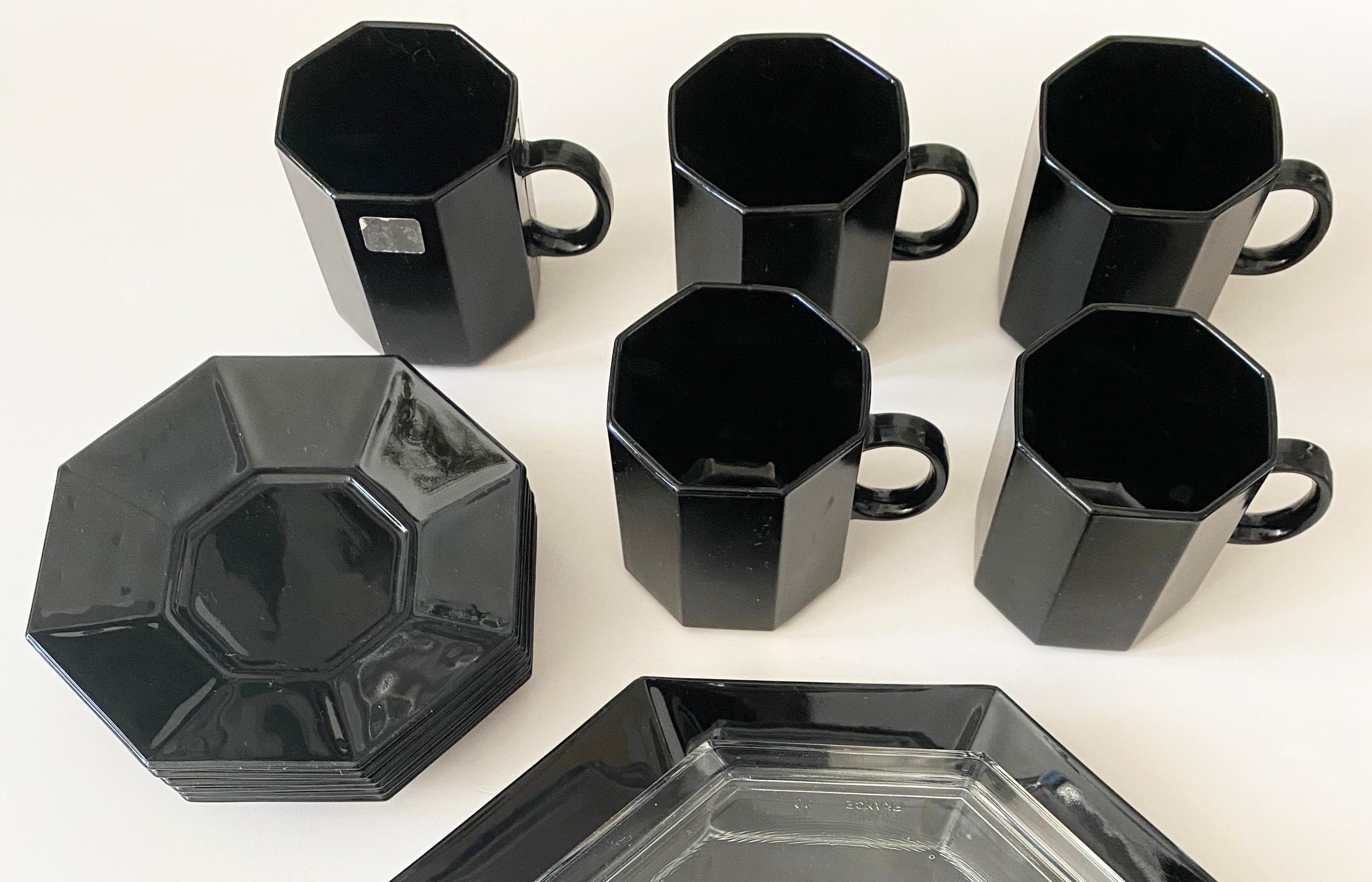 Voici un magnifique ensemble de 5 tasses à thé et soucoupes en verre noir, ainsi qu'un plat à gâteau avec couvercle en dôme de verre, du célèbre fabricant français Arcoroc. Fait partie de la gamme Octime, très appréciée pour ses articles ménagers en