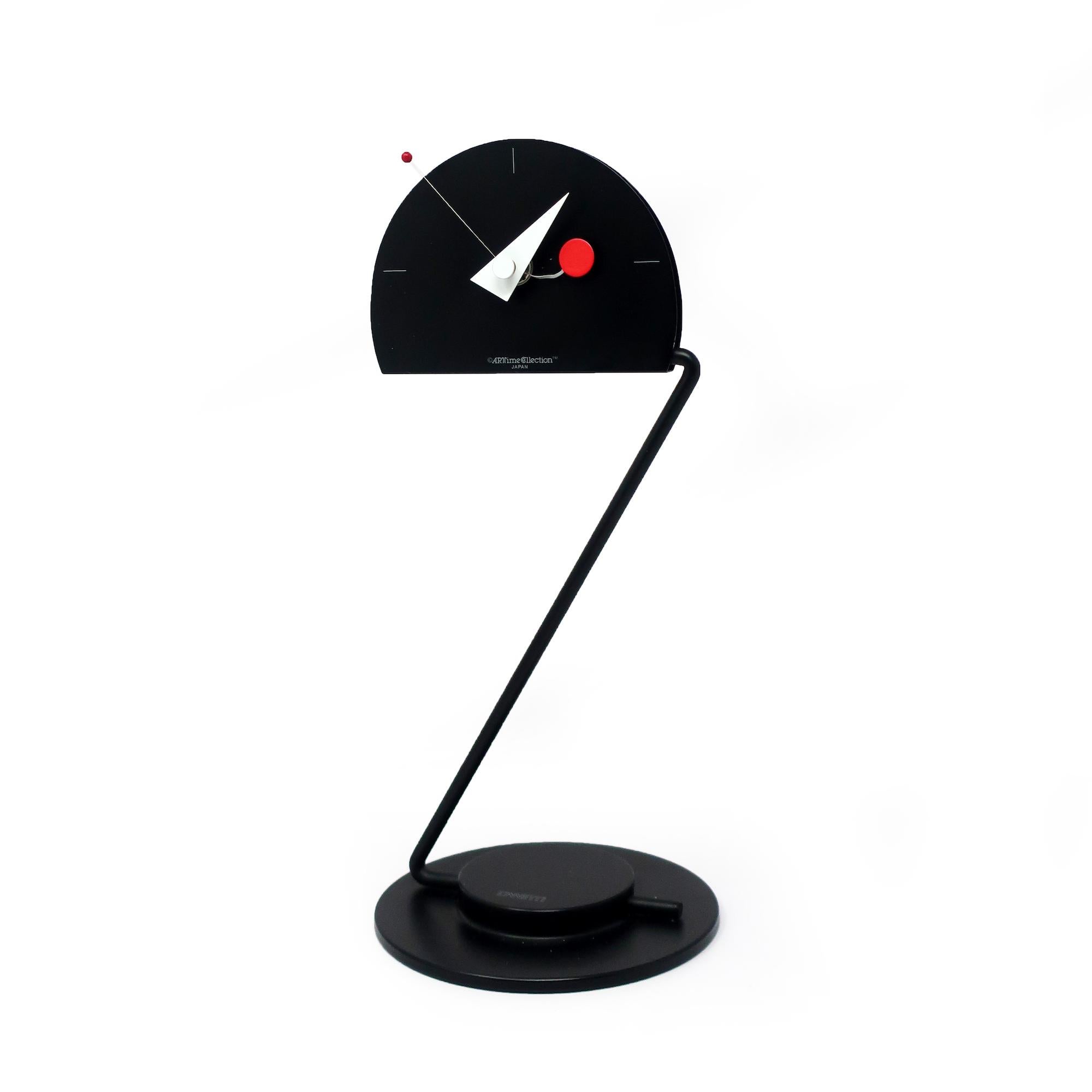 With a round black metal base, articulating black metal stem, semicircle face and geomantic hands, this amazing Artime Collection desk clock by Canetti has all of the elements of great 1980s postmodern design: primary colors, simple lines, wacky