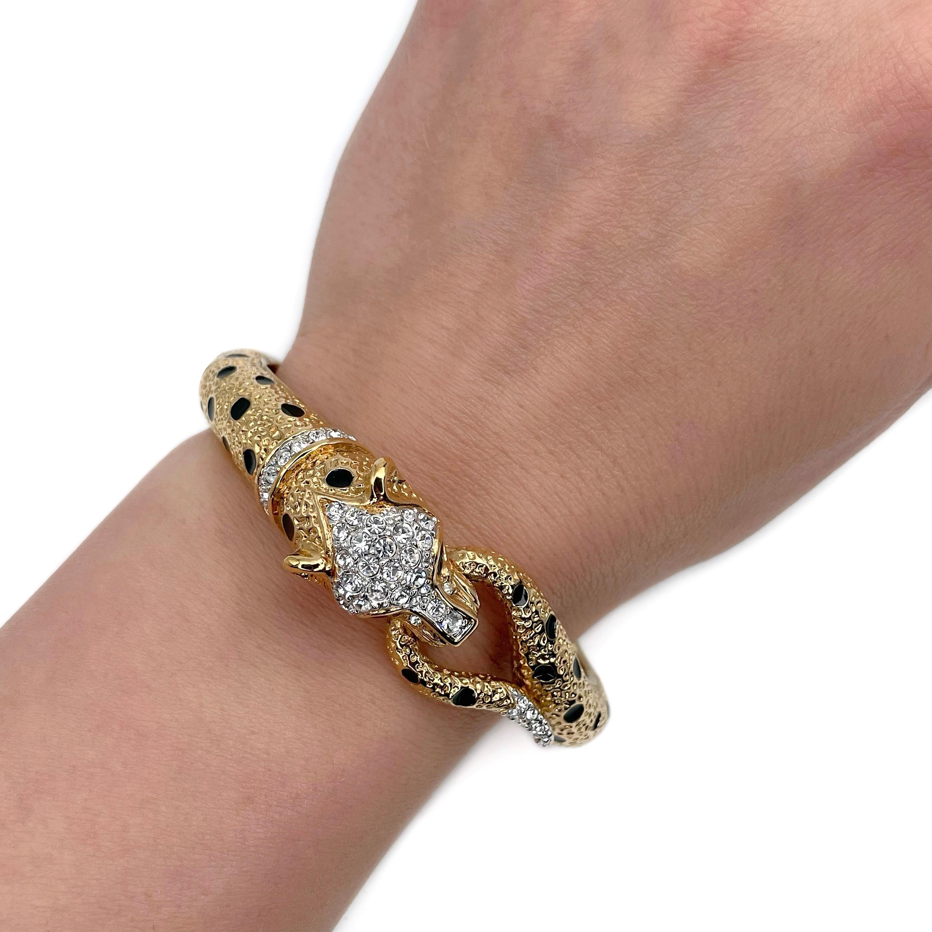 This is a vintage leopard hinged bangle bracelet designed by Attwood & Sawyer in 1980’s. The piece is crafted in base metal and is gold plated. It is adorned with black enamel and clear crystals. 

Signed: “A&S” (shown in photos).
Inner