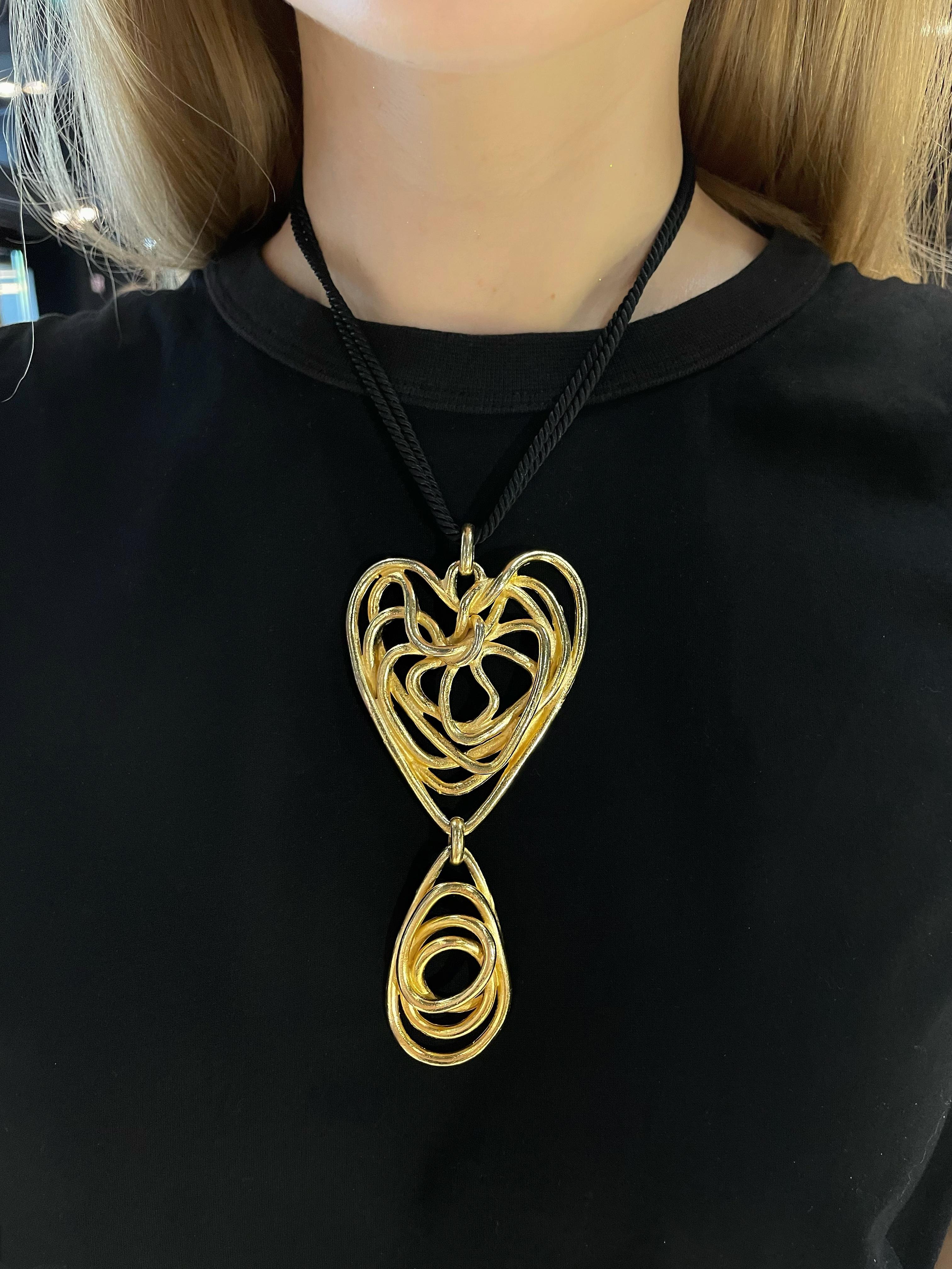 This is a beautiful massive wired spiral heart pendant necklace designed by Balenciaga in 1980’s. This piece is gold plated. It features black double strand twisted silk rope finished with gilt metal beads. 

Signed: 