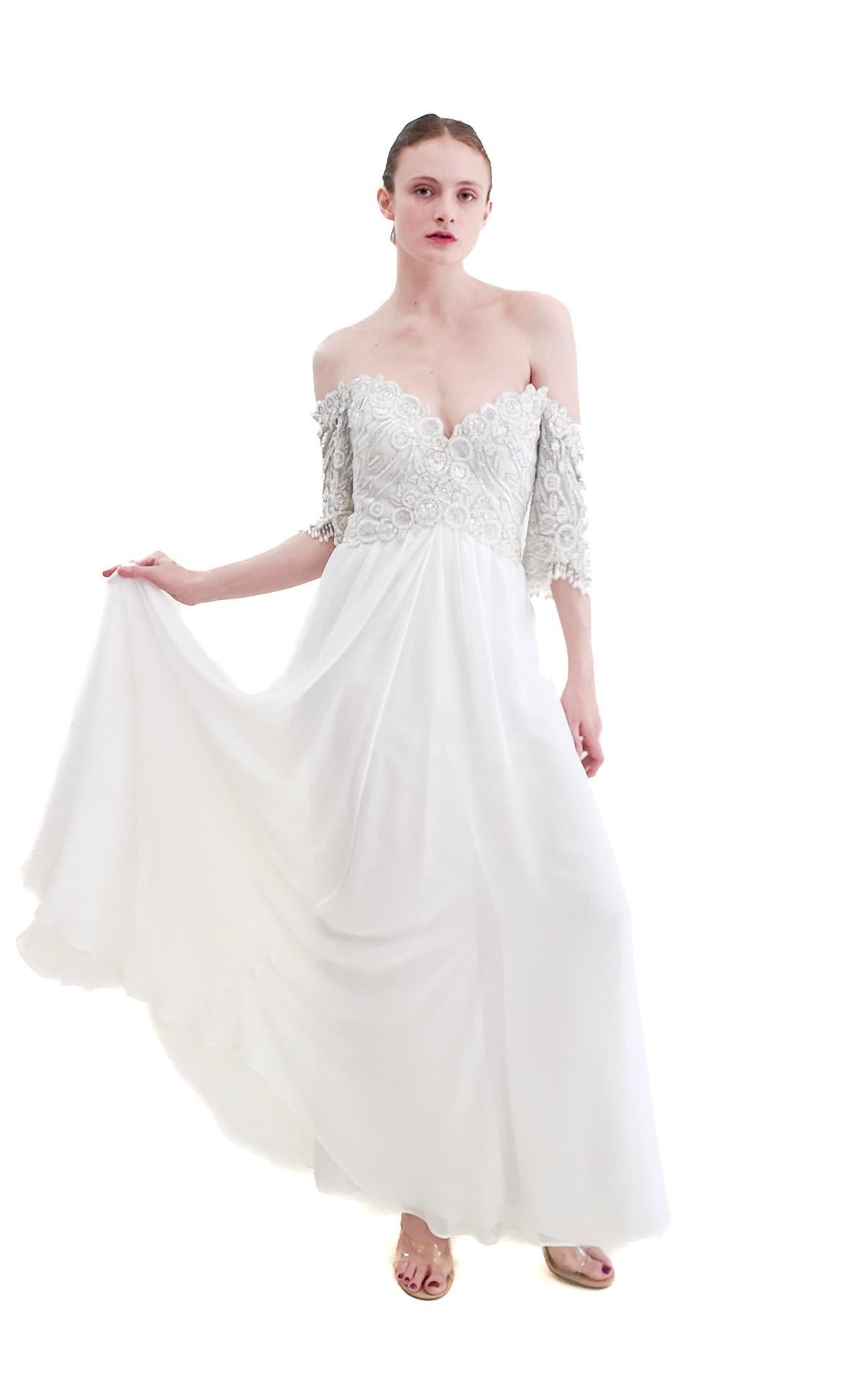 Elevate your bridal style with our 1980's Bob Mackie White Gown. This off-shoulder gown features a stunning beaded bodice and a sweetheart cup, perfect for the vintage bride. Step back in time with this true 80s vintage
