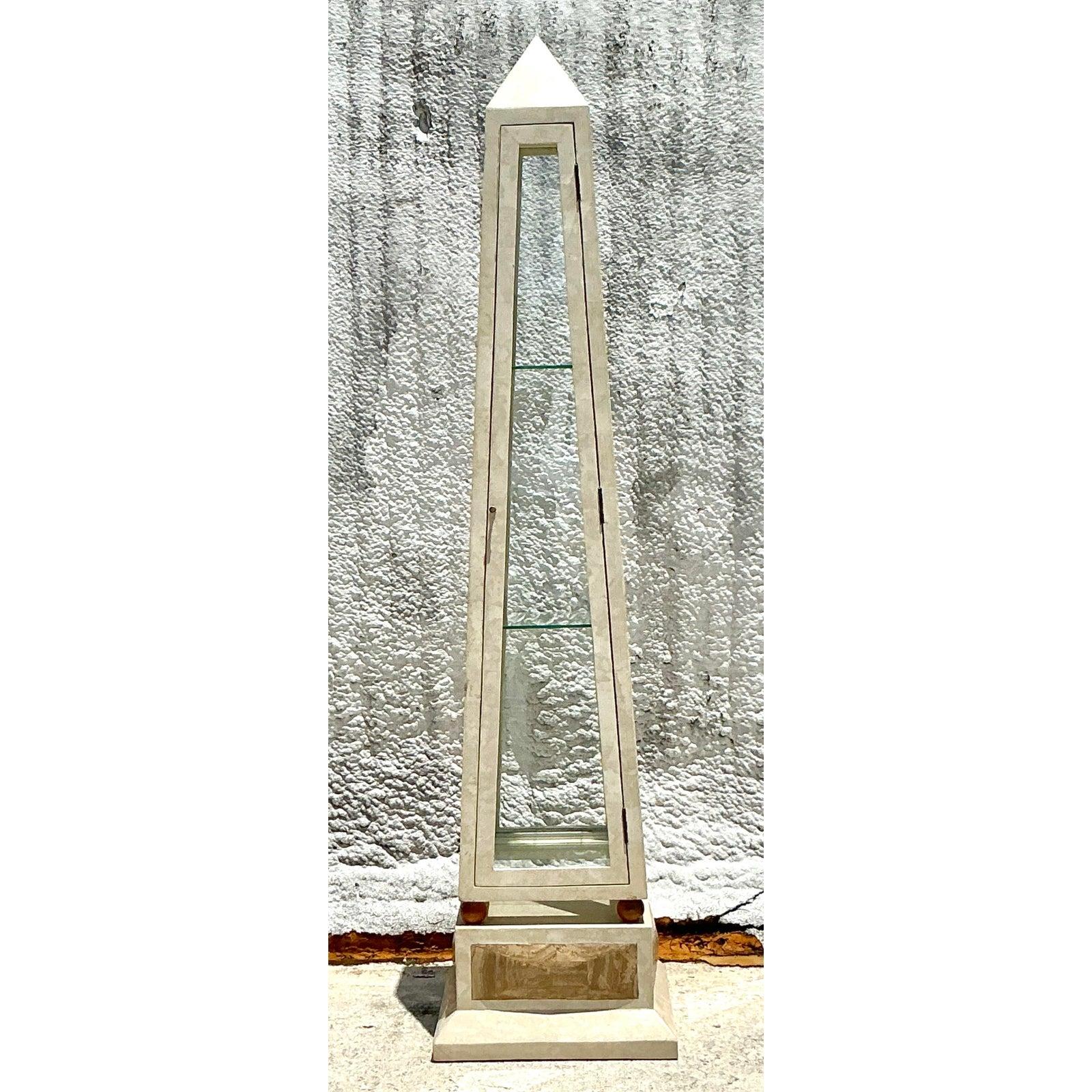 Make a monumental statement with this rare and captivating Vintage Tessellated Stone Obelisk Etagere, a true fusion of classical form and Postmodern design. This striking piece commands attention with its towering obelisk silhouette, meticulously