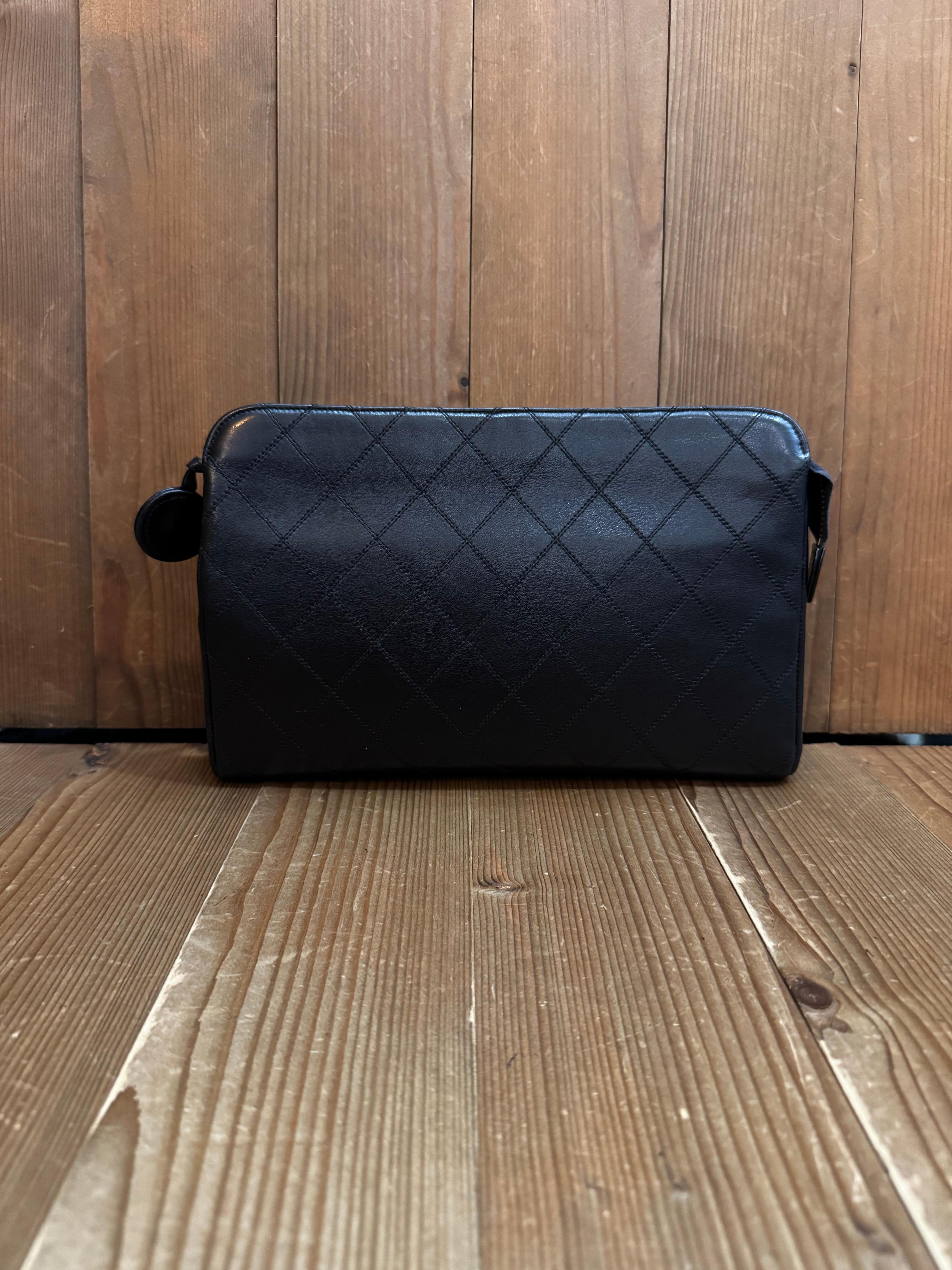 This vintage Chanel clutch bag is crafted of diamond quilted lambskin leather in black and gold toned hardware. Top brass zipper closure opens to a lambskin Interior refurbished by Chanel in Japan (repair seal 00-5-23 dated May 23rd 2000) with the