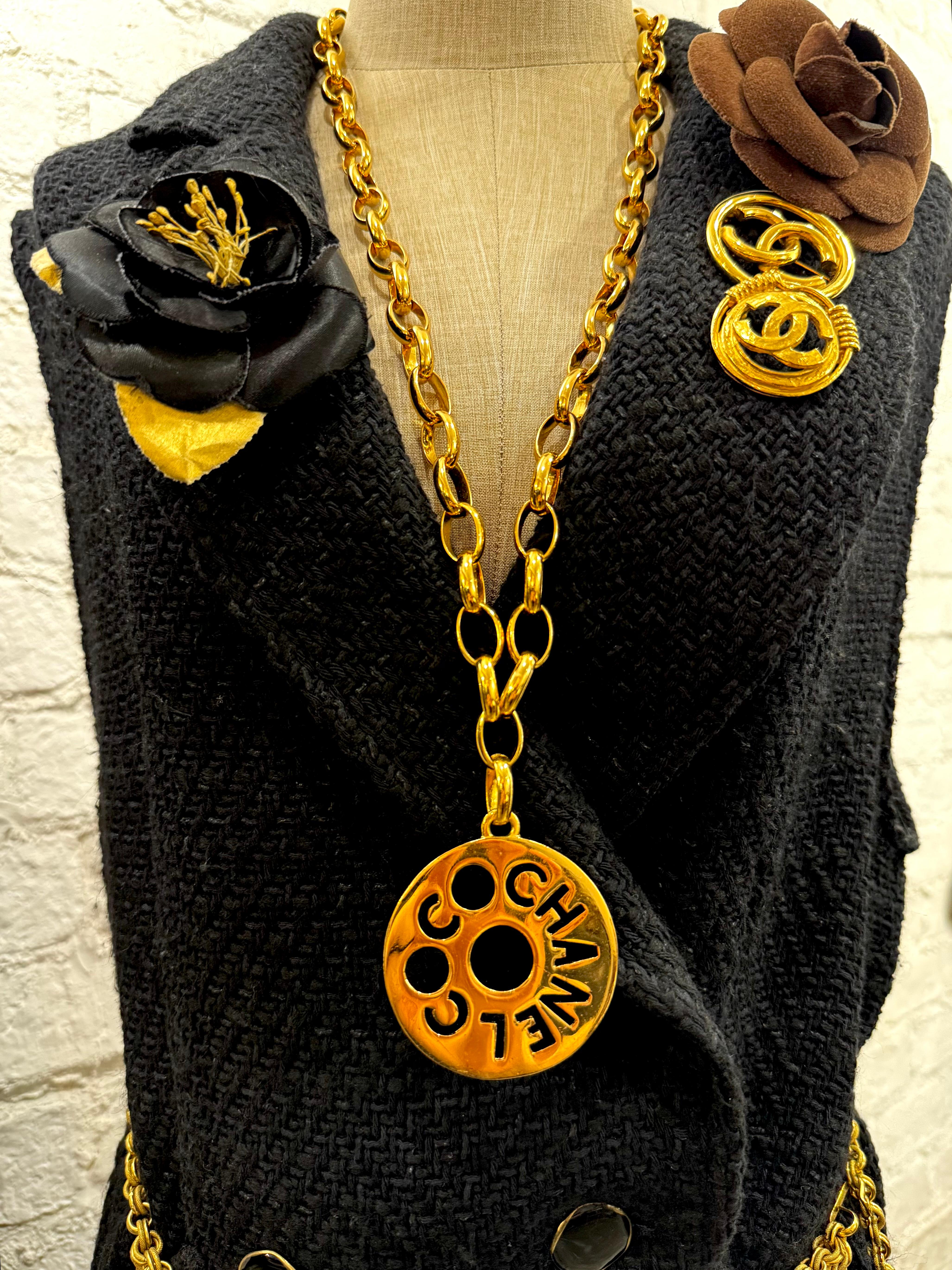 Este collar de cadena vintage de Chanel está fabricado con una robusta cadena ovalada dorada con un enorme colgante de letra recortada COCO CHANEL. Estampado CHANEL. Cierre de gancho ajustable. La longitud mide aproximadamente 31,75 pulgadas El