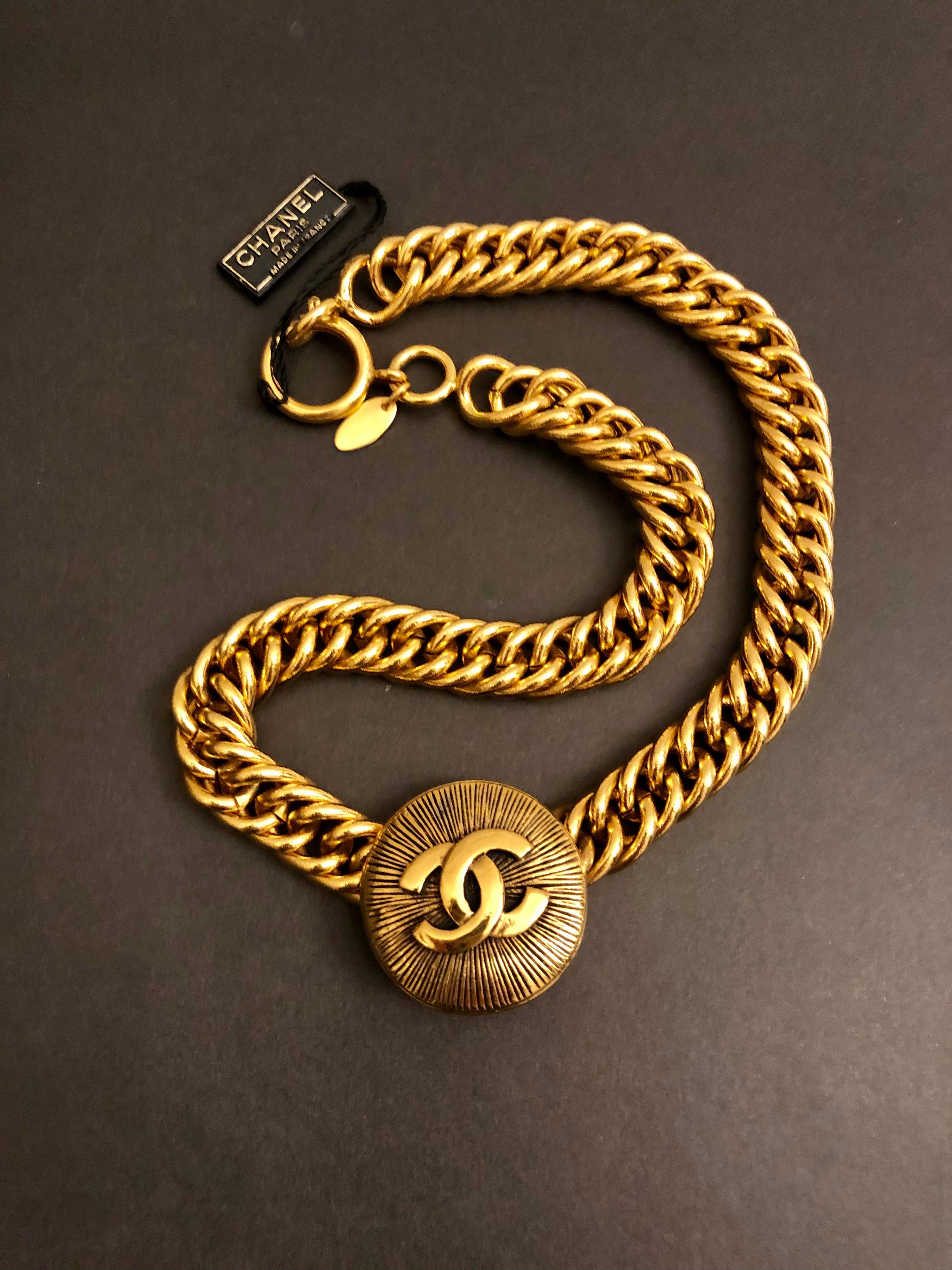 This vintage CHANEL short chain necklace is crafted of sturdy gold toned chain centered a Byzantine CC coin charm. Measures approximately 42 cm Coin 3.2 cm in diameter. Stamped Chanel made in France. Spring ring closure. Comes with box and