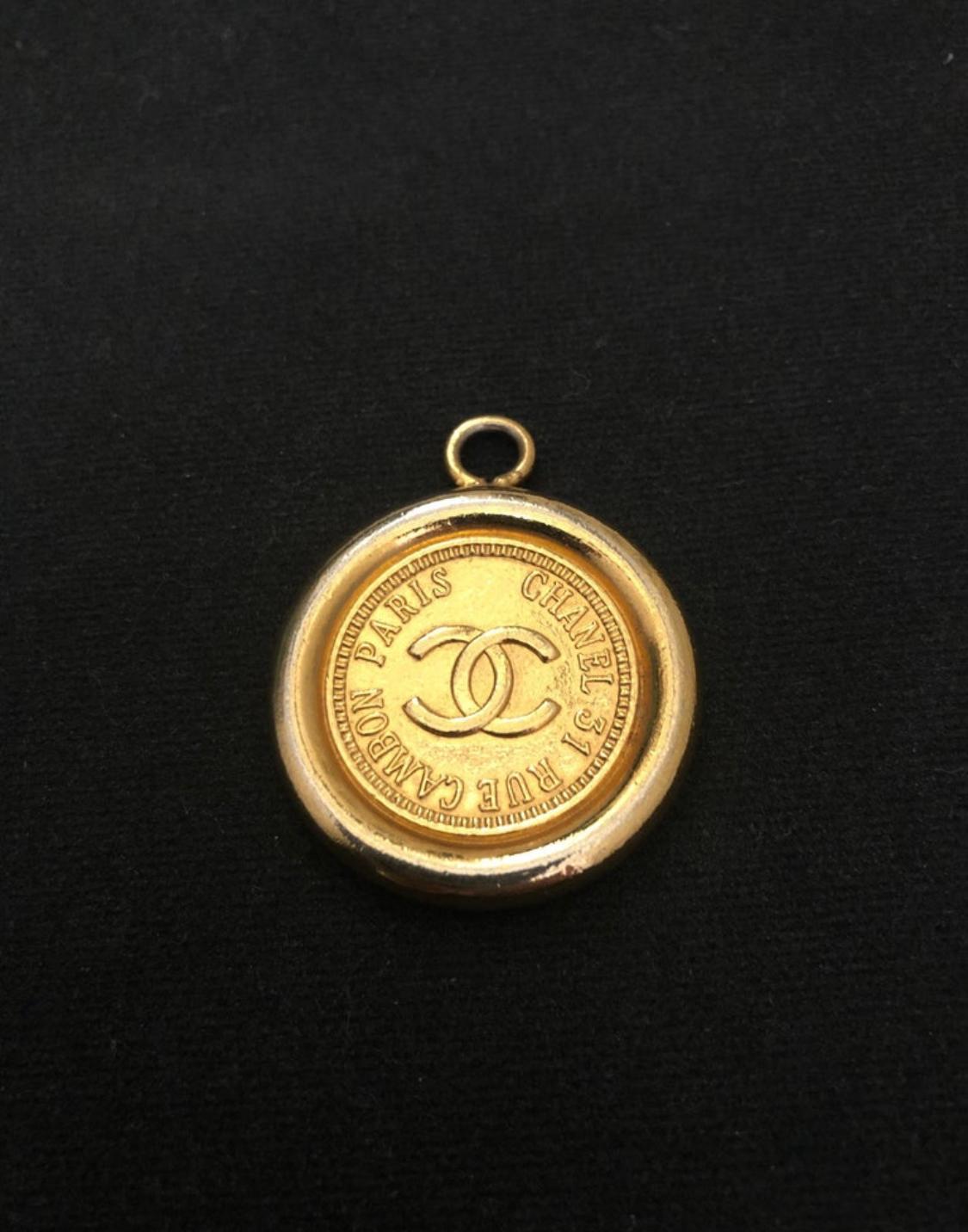 Este colgante vintage CHANEL de moneda dorada para cinturón está fabricado en metal chapado en oro. Formaba parte de un cinturón de cadena vintage de Chanel de los años 80. Mide 3,3 cm de diámetro. 

Estado: Algunos signos de desgaste acordes con la