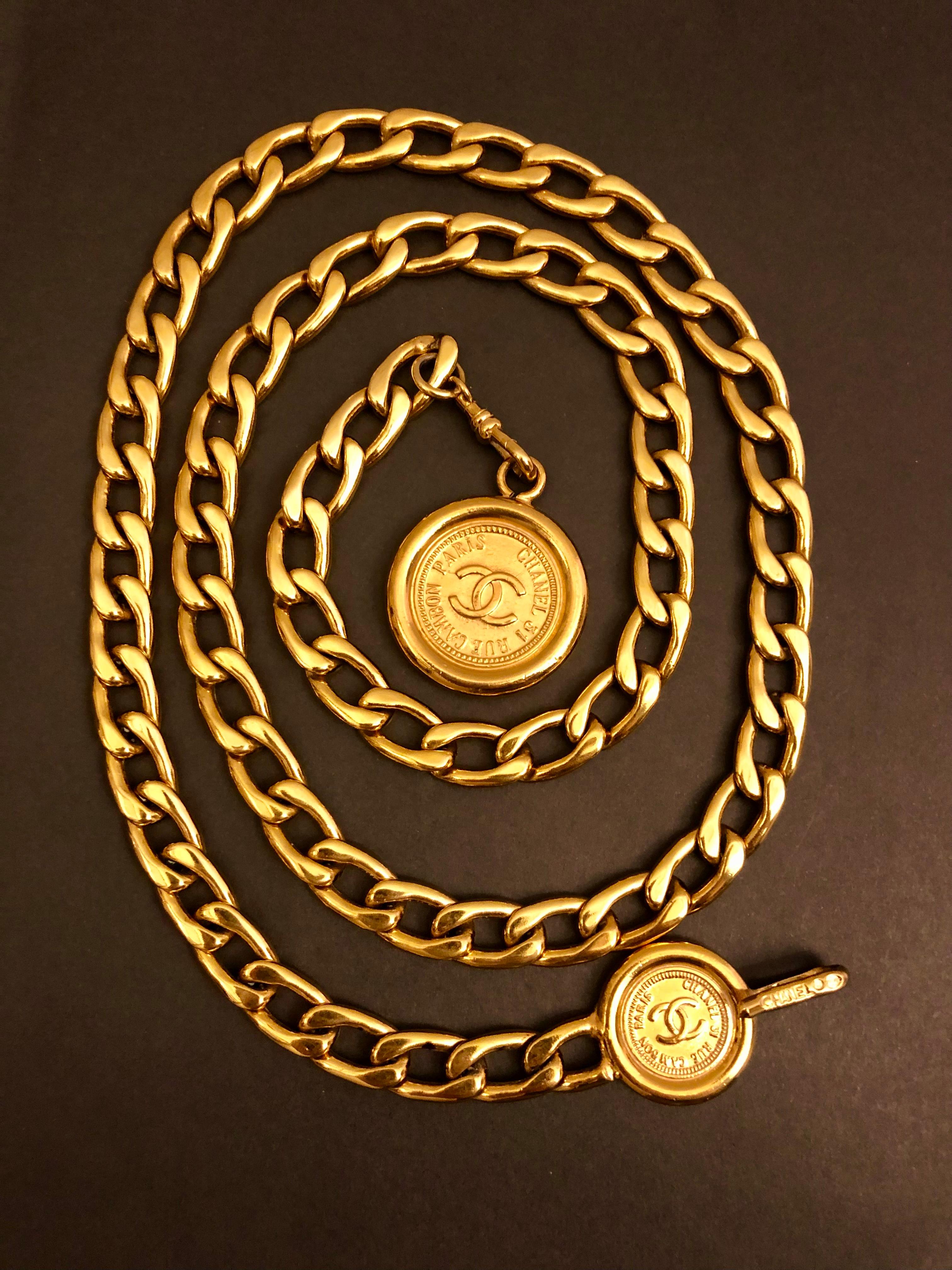 This vintage CHANEL chain belt is crafted of gold toned chain featuring two Chanel Cambon coins. Stamped CHANEL. Adjustable hook fastening. Total length measures approximately 37 inches fits waist up to 34 inches. 

Condition - Good vintage