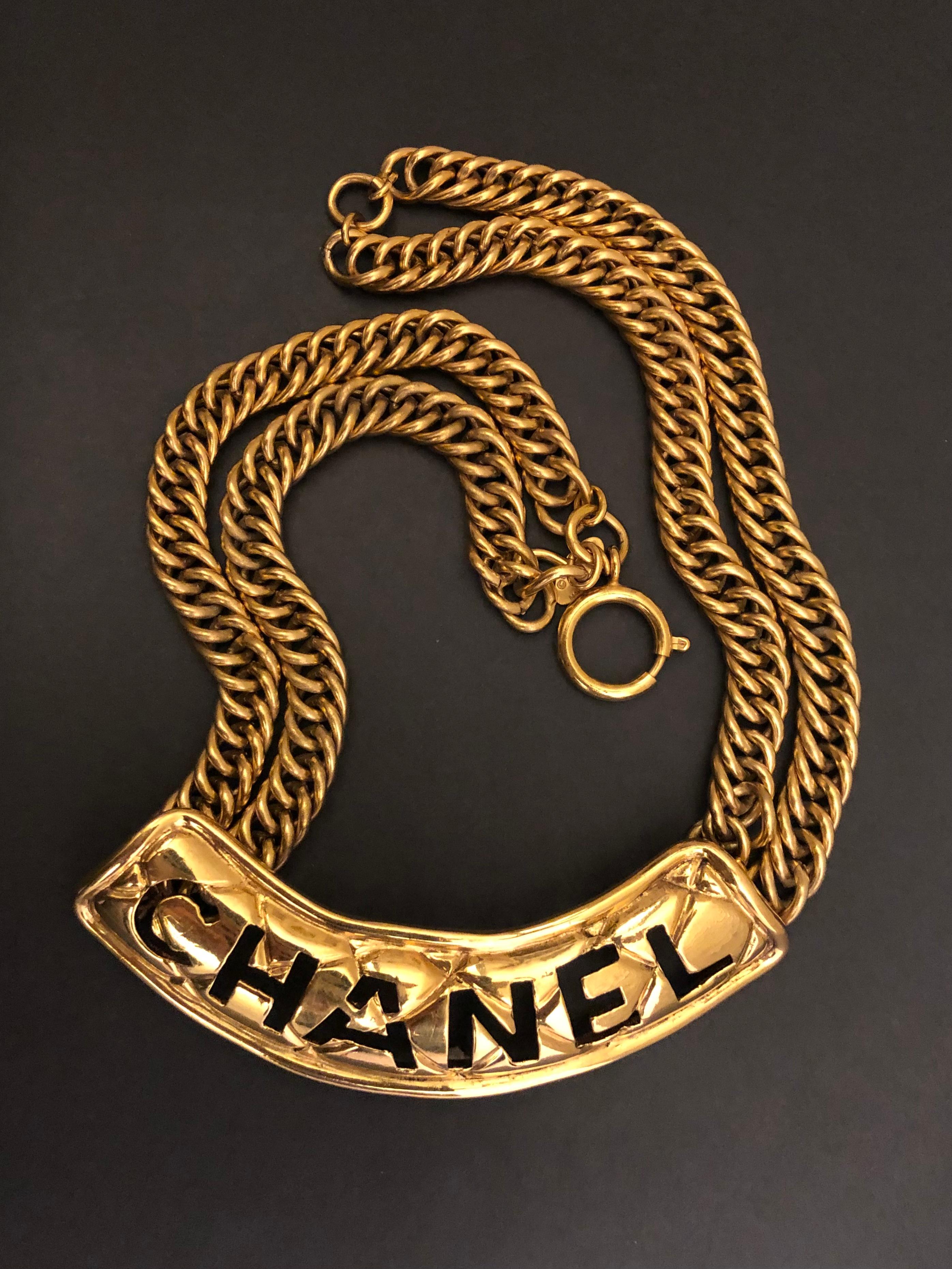 This vintage CHANEL gold toned chain necklace is crafted if gold toned metal featuring double chains and a cut-out CHANEL plate in quilted pattern. Spring ring closure. Stamped CHANEL made in France. Measures approximately 43 cm Charm. Comes with