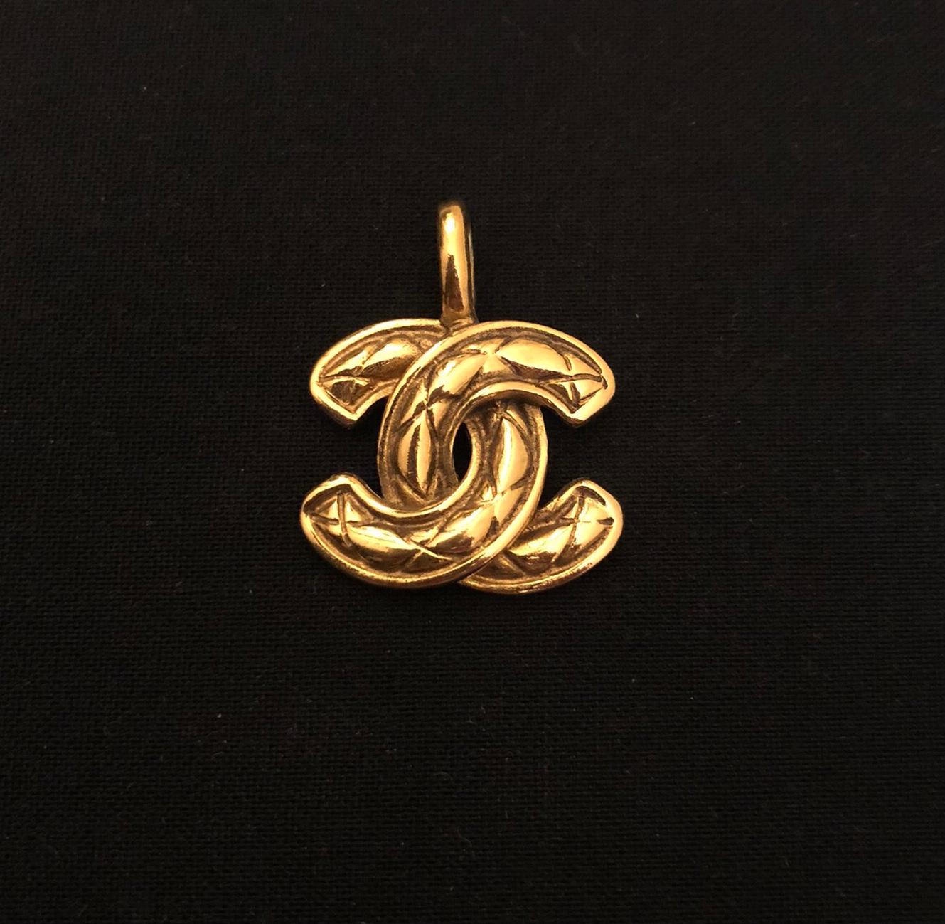 1980s vintage Chanel gold toned quilted CC pendant charm once belonged to a short chain necklace. You can secure it on your favorite gold toned chain or pearl necklace as in the picture. Measures approximately 3 x 2.5 cm. The cultured pearl necklace