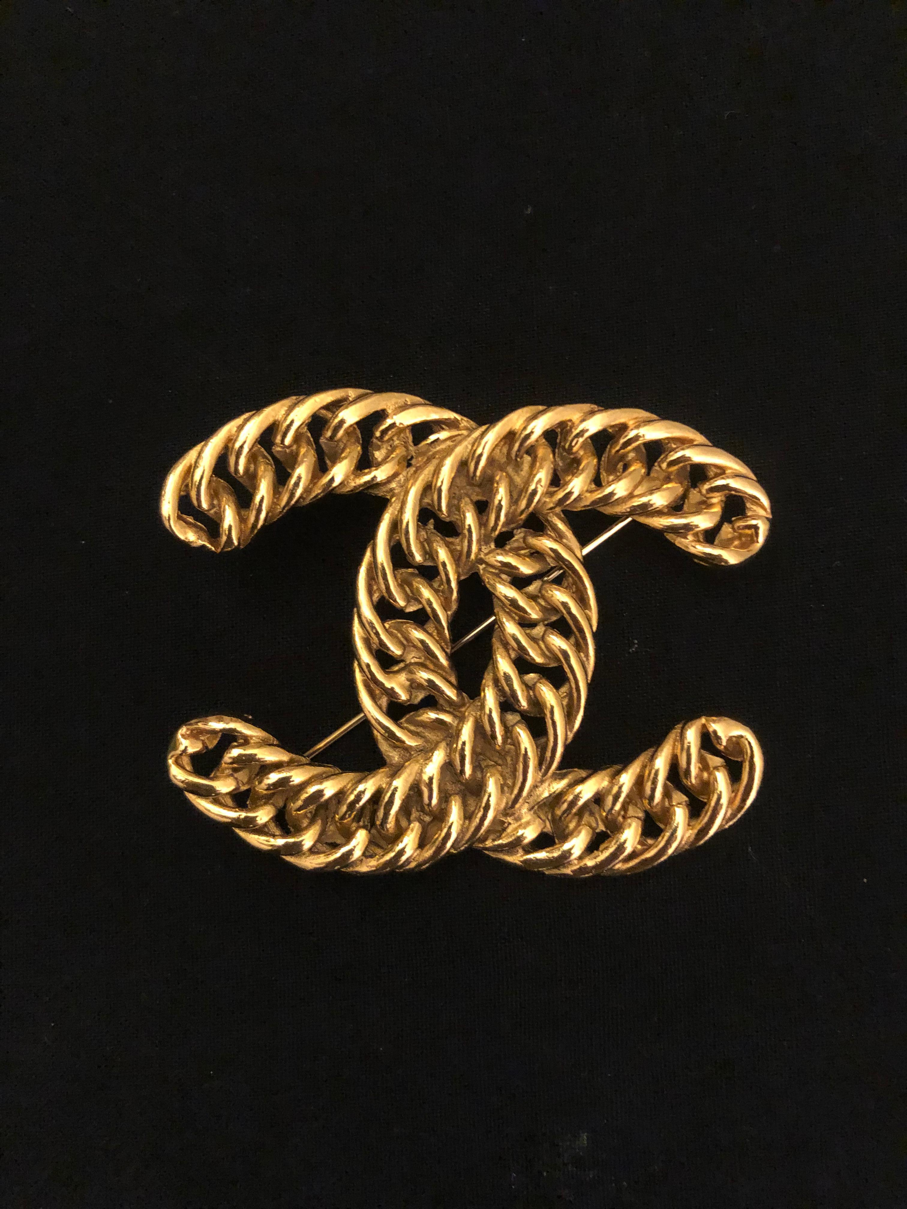 1980s CHANEL iconic massive gold toned brooch in intertwined chain CC logo. Stamped 1107. Measures approximately 6.6 x 5.3 cm.

Condition: Minor signs of wear. Generally in very good condition.