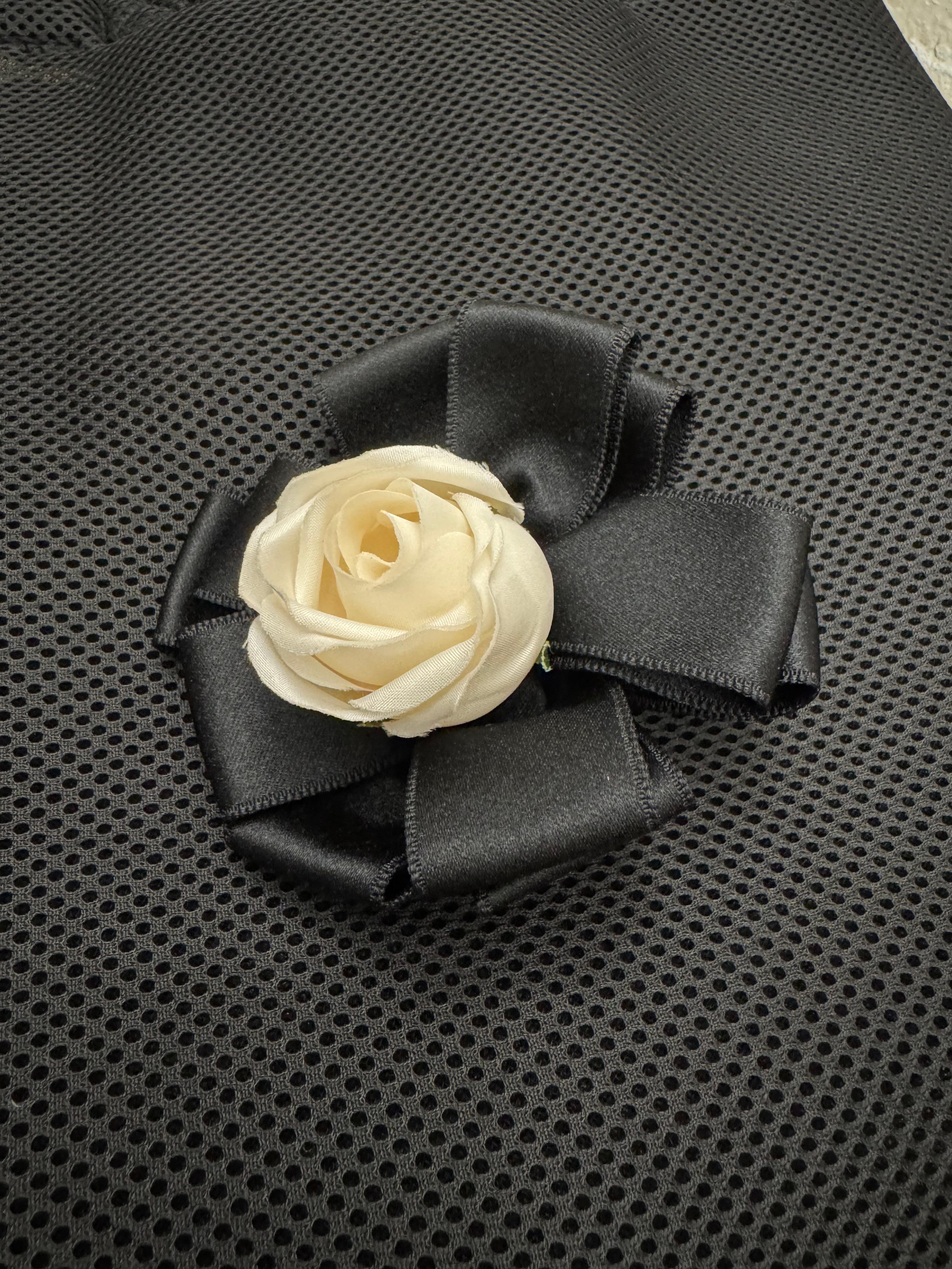 This vintage CHANEL massive camellia brooch is crafted of eleven black ribbon folds adorned with a white polyester camellia in the middle. Stamped CHANEL made in France. Measures approximately 10 x 10 x 5 cm. Comes with box.

Condition: Very good