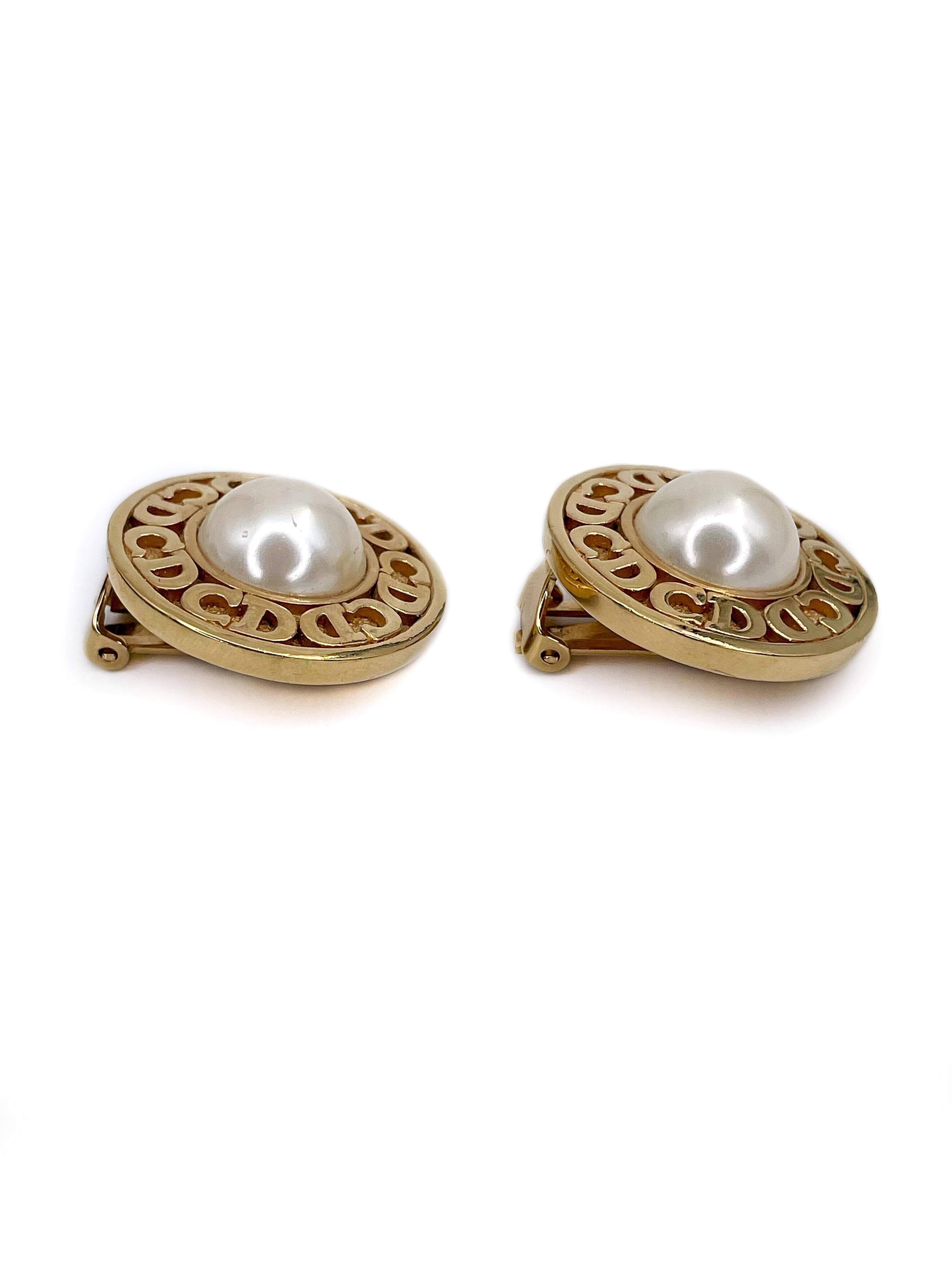 This is a classic and elegant pair of round clip on earrings designed by Christian Dior in 1980’s. The piece is gold plated, adorned with CD monograms and features faux pearls at the center. 

Markings: “Chr. Dior©Germany” (shown in