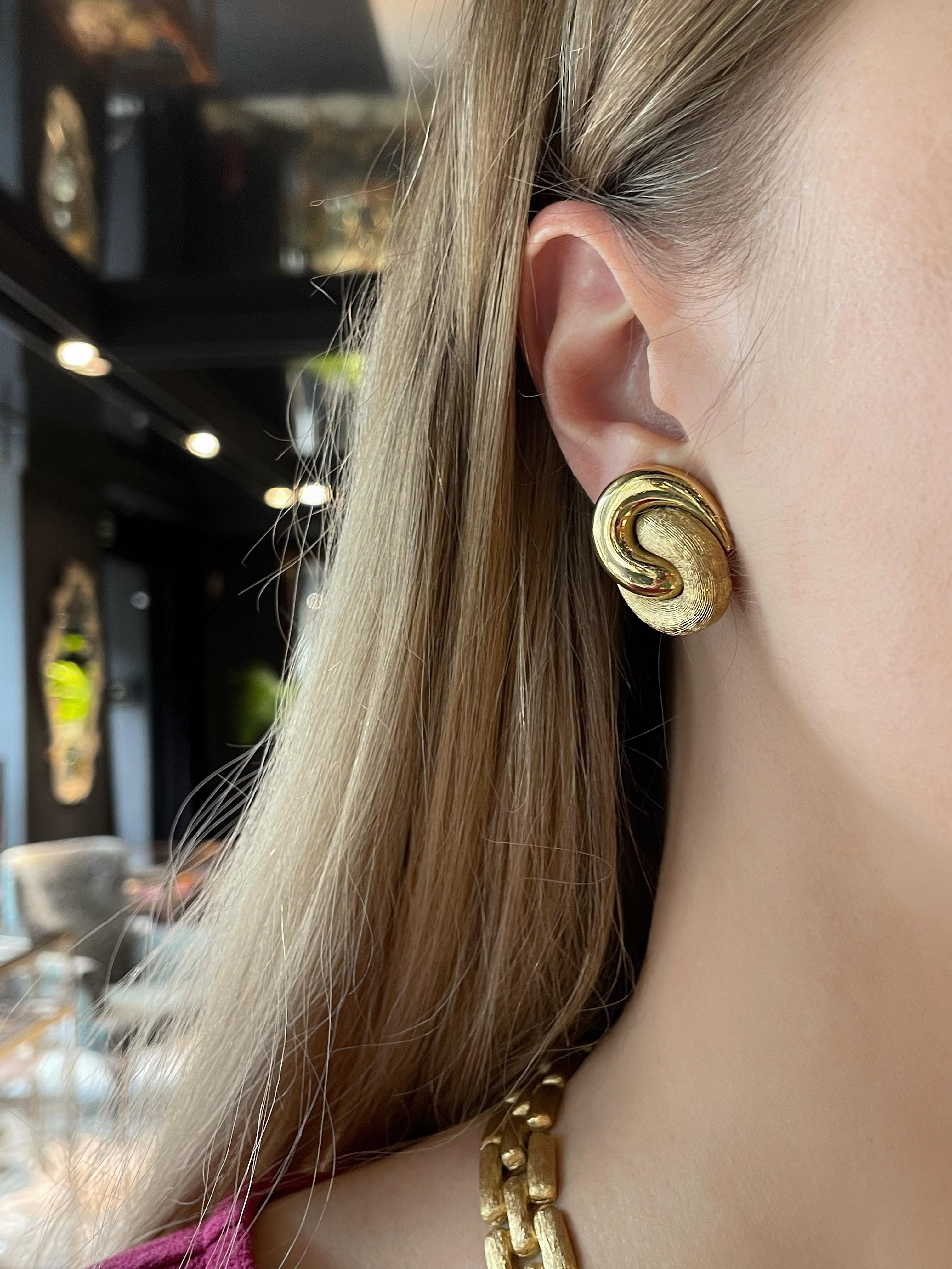 This is a vintage pair of stylish knot twist clip on earrings designed by Christian Dior in 1980’s. The piece is gold plated. Featuring entwined loops of polished and textured base metal depicting a knot. 

Signed: 