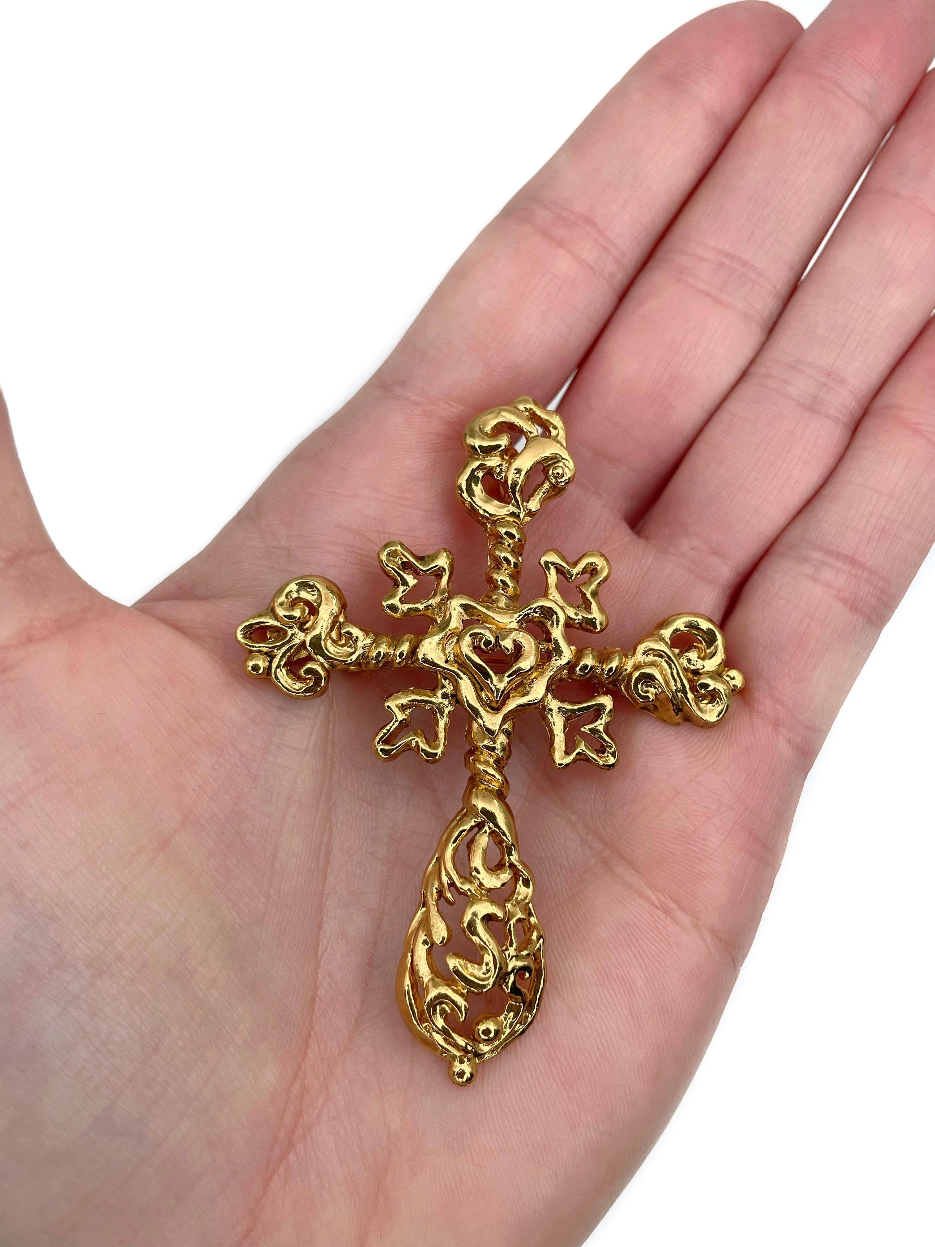 Este es un increíble broche y colgante en forma de cruz calada de estilo barroco en tono dorado. Fue diseñado por Christian Lacroix en la década de 1980. La pieza está chapada en oro. 

Firmado: 