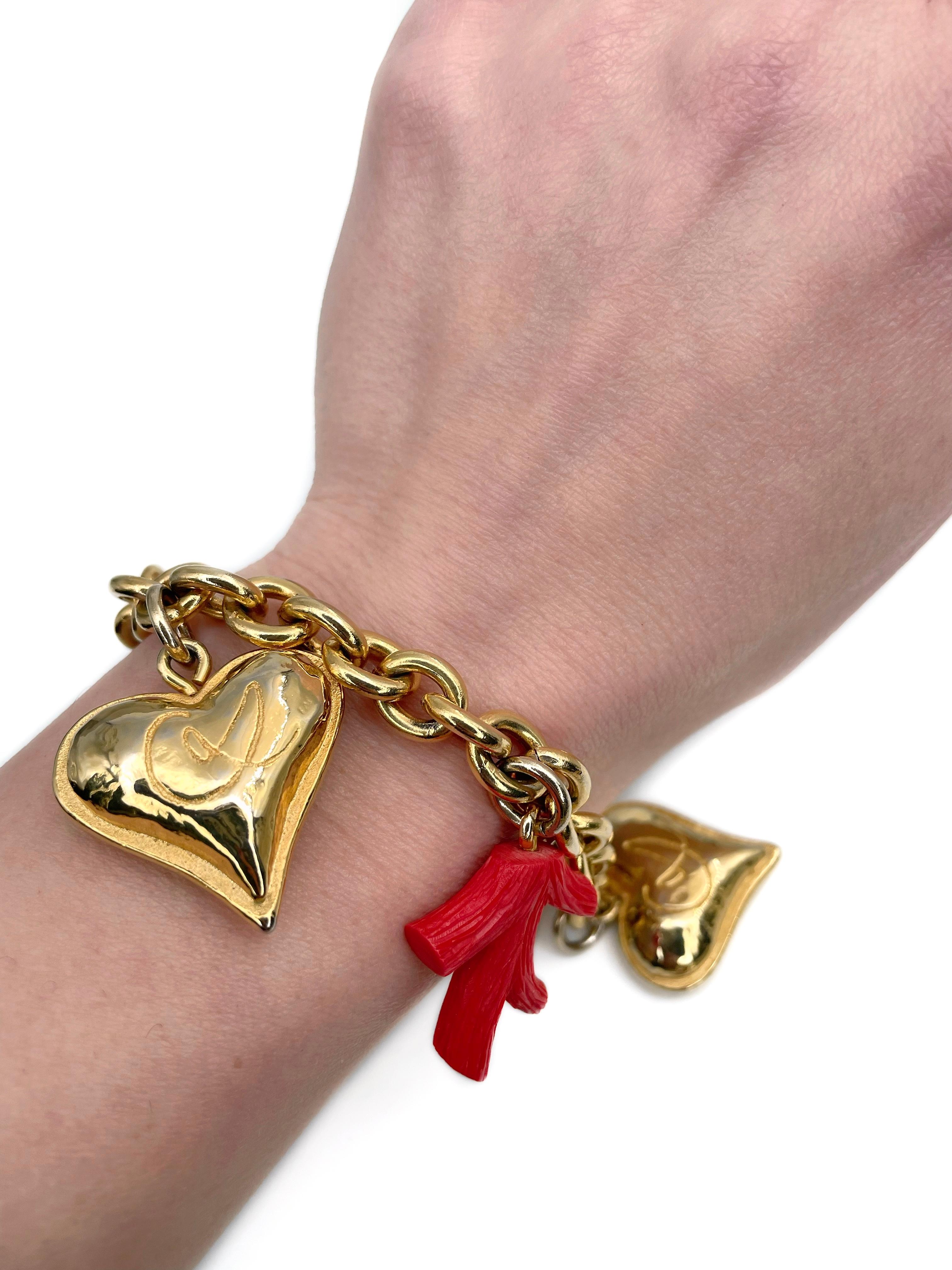 Dieses Armband ist ein Entwurf von Christian Lacroix aus den 1980er Jahren. Er ist aus unedlem Metall gefertigt und vergoldet. 

Das Stück besteht aus Herzen mit Logo und künstlichen Korallenzweigen aus Harz.  

Länge: ~19cm

WICHTIG: Als Käufer