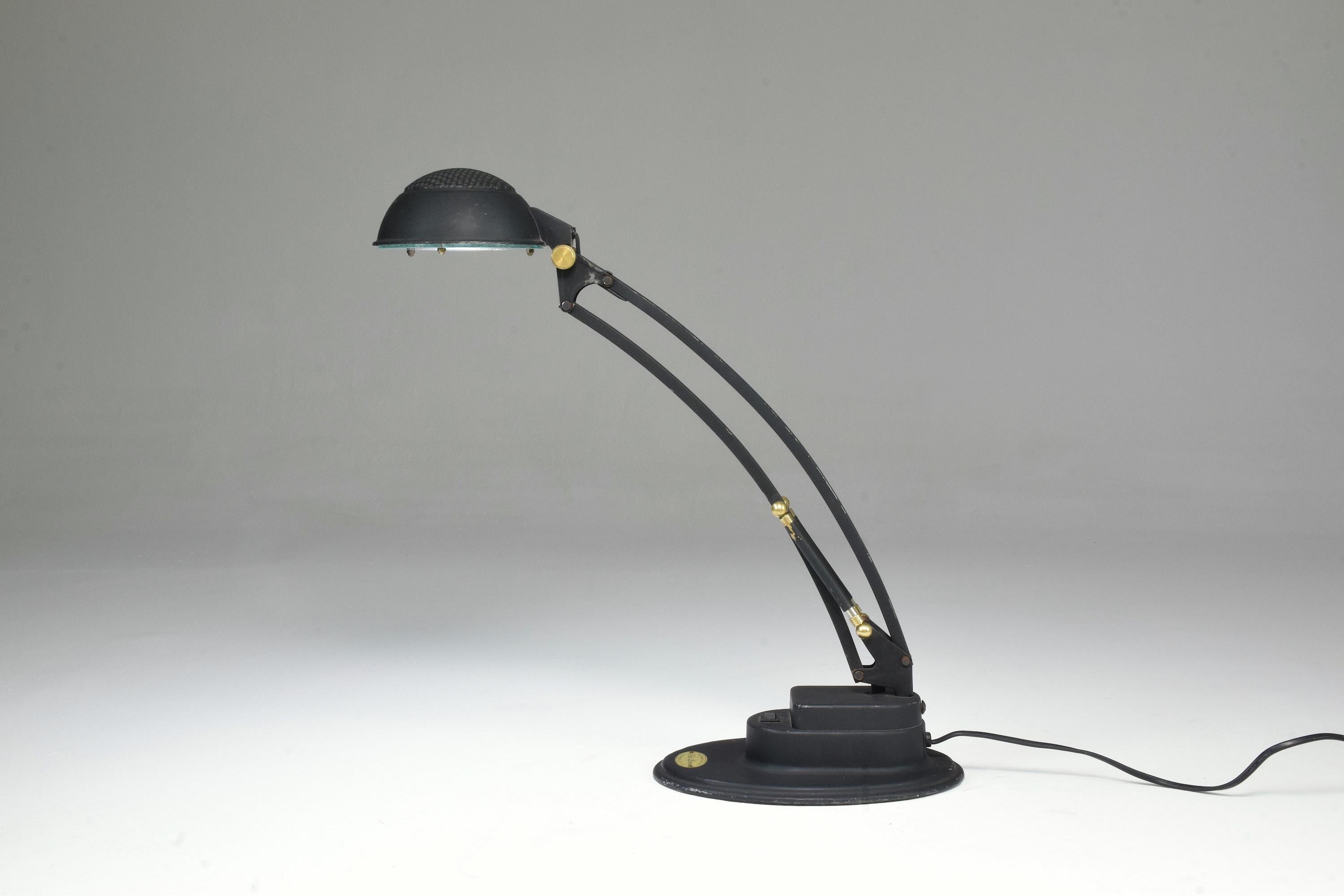 An interesting retro-modern style desk light built out of steel and aluminum. The polished brass details give this piece a chic appeal. This piece rotates both at the base and at the shade. 
UK, circa 1980s. 
Labled Starpick Lighting
The original