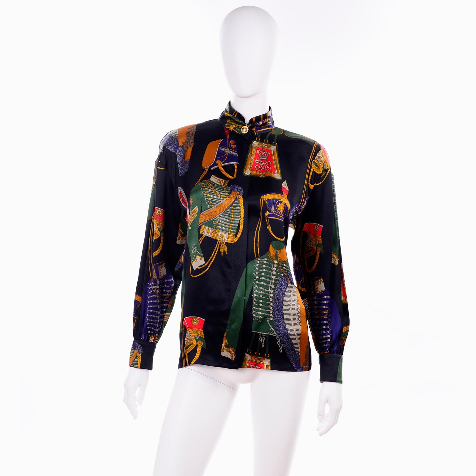 This vintage Escada silk blouse was designed by Margaretha Ley and made in Germany in the 1980's.  The blouse fabric is a Deep green, red, blue, gold and cream novelty print that includes various antique military soldier's costumes and there is a