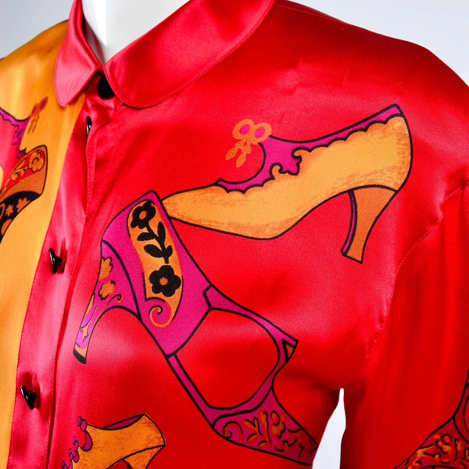 This fun Escada vintage silk blouse was designed by Margaretha Ley in the 1980's.  The blouse is in a red and gold novelty print silk with pointed shoes in red, pink, yellow and purple.  The blouse is labeled a European size 36 and buttons up the