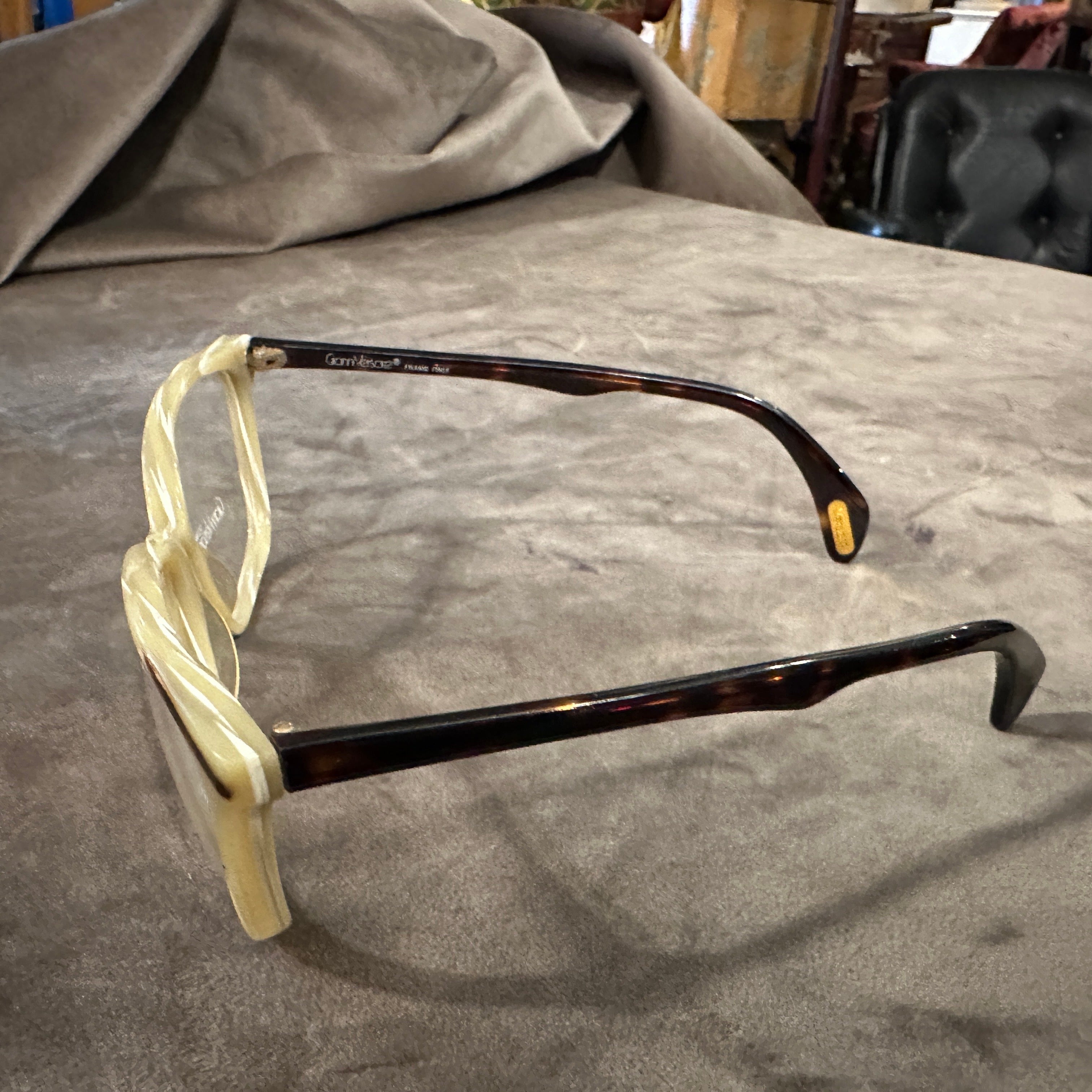 Entra nella raffinatezza retrò con questi splendidi occhiali da sole vintage anni '80 di Gianni Versace. Caratterizzati da un'audace montatura di ispirazione cat-eye realizzata in un leggero acetato simile al corno con sottili sfumature, questi