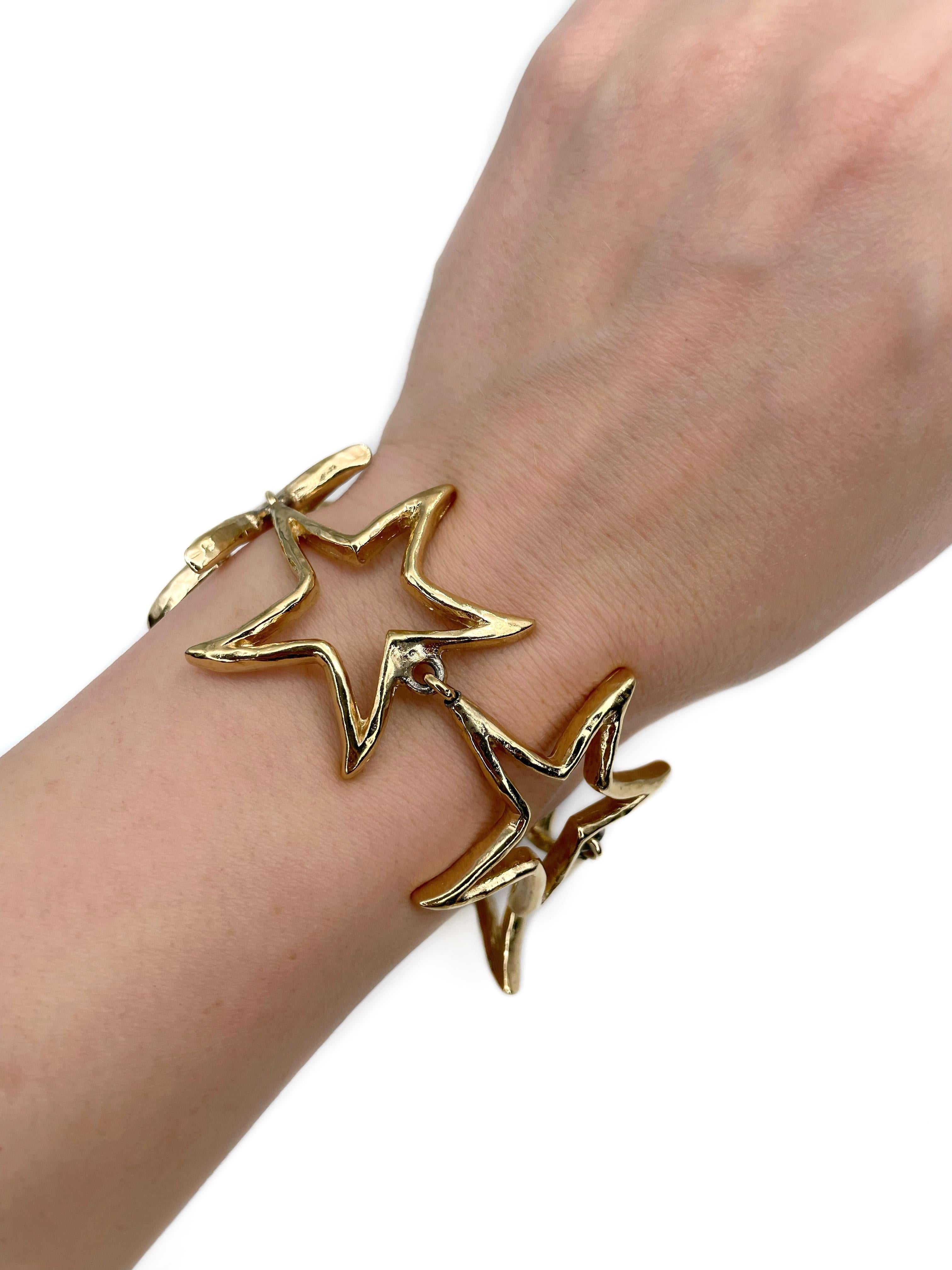 Dies ist ein Vintage-Stern Gliederarmband von Givenchy in den 1980er Jahren entworfen. Das Stück ist aus goldfarbenem, unedlem Metall gefertigt. 

Länge: 19-24cm

WICHTIG: Als Käufer sind Sie in vollem Umfang für die Zollgebühren, andere lokale