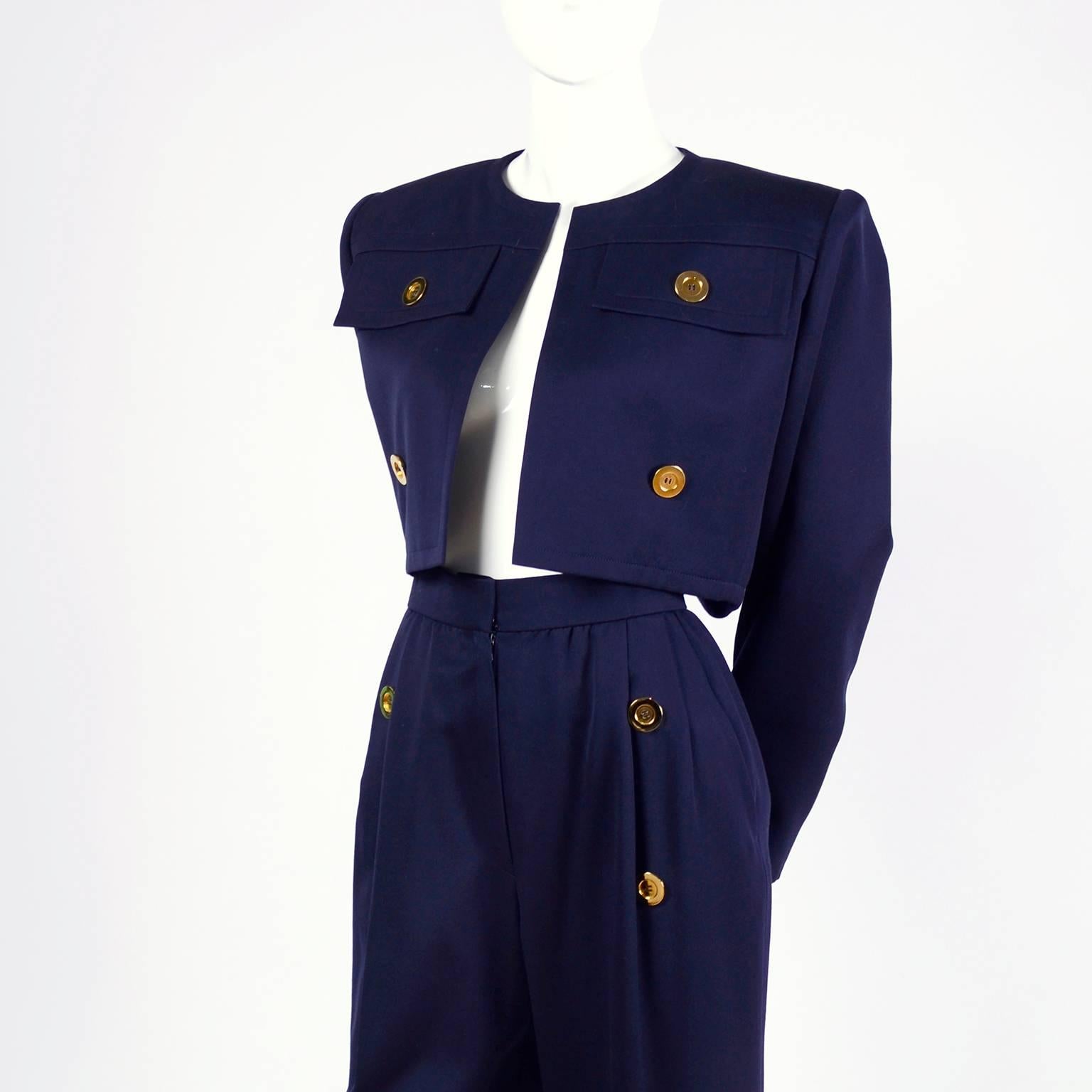 This midnight blue Givenchy pantsuit is from the 1980’s. The Givenchy Nouvelle Boutique suit is fully lined and features a pair of high waisted pants and a cropped jacket with shoulder pads. Both pieces have pretty gold buttons and the pants close