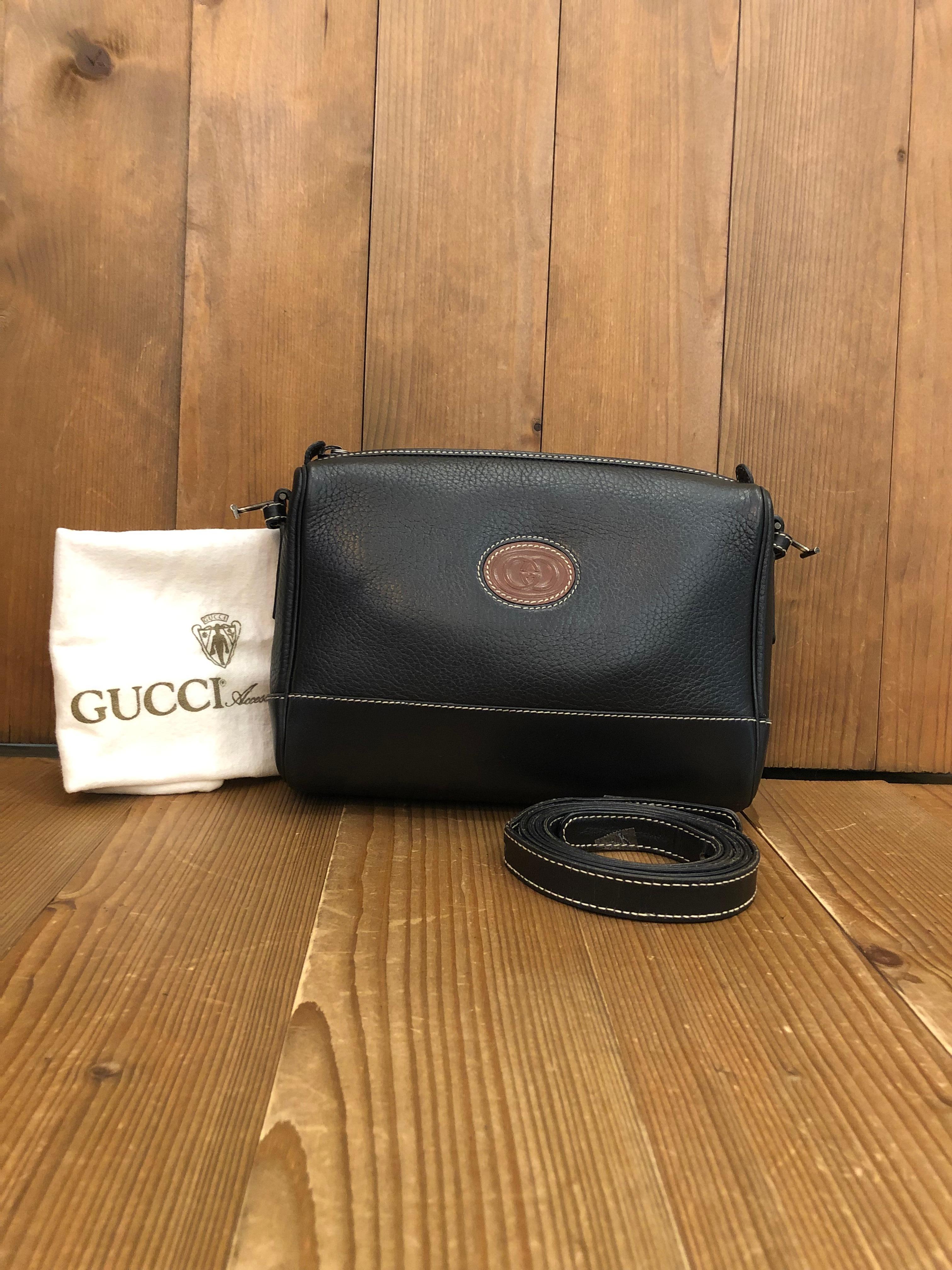1980s Gucci small crossbody bag in black leather featuring black toned hardware and  all black suede leather interior. This compact crossbody bag has one interior zip pocket. Top zip closure. Made in Italy. Measures approximately 8.25 x 6 x 2.5