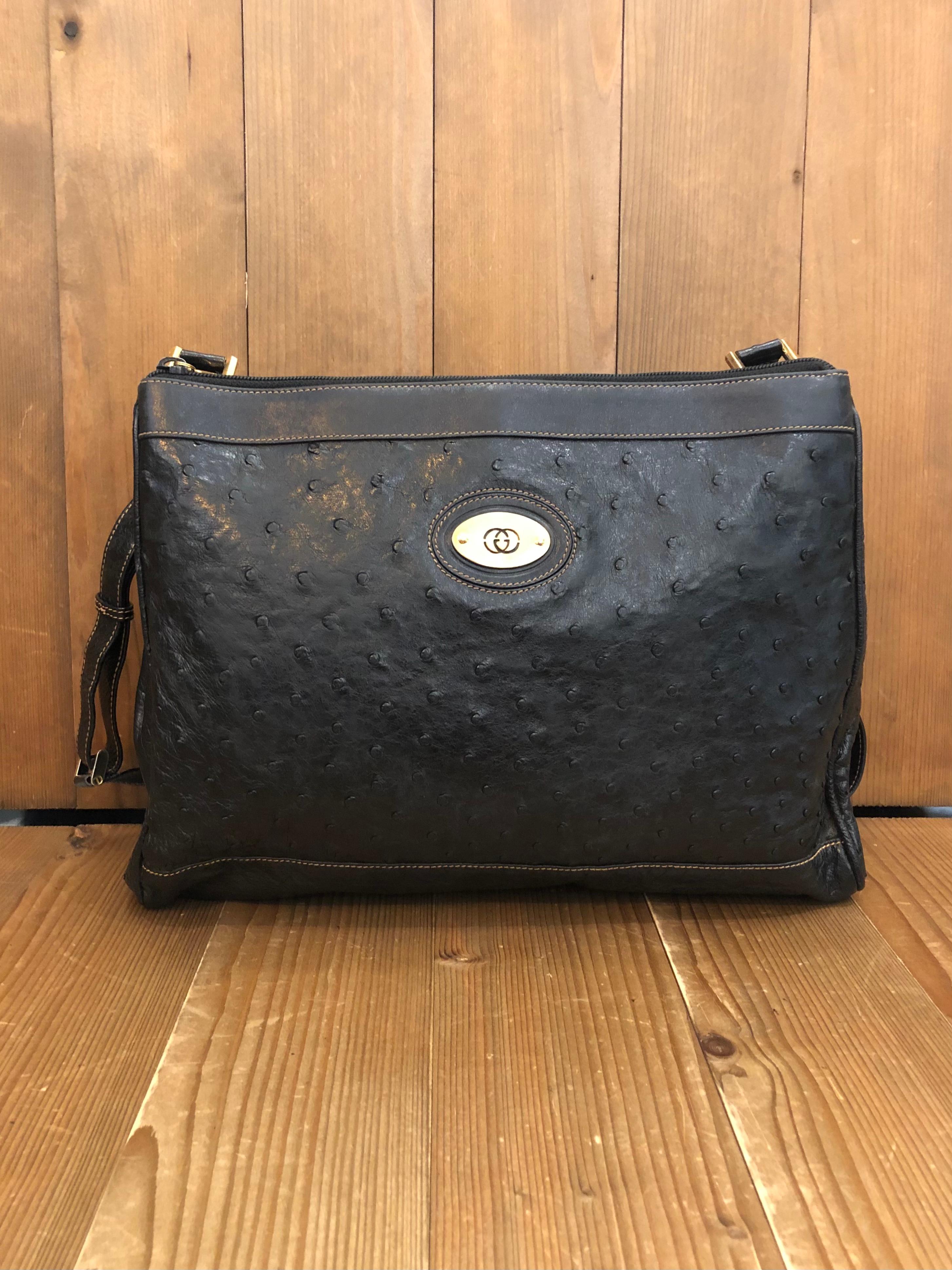 1980s Gucci messenger bag in black ostrich leather featuring gold toned hardware and all black suede leather interior. The strap of the same leather can be adjusted to wear it as a shoulder or crossbody bag. This messenger bag has two spacious
