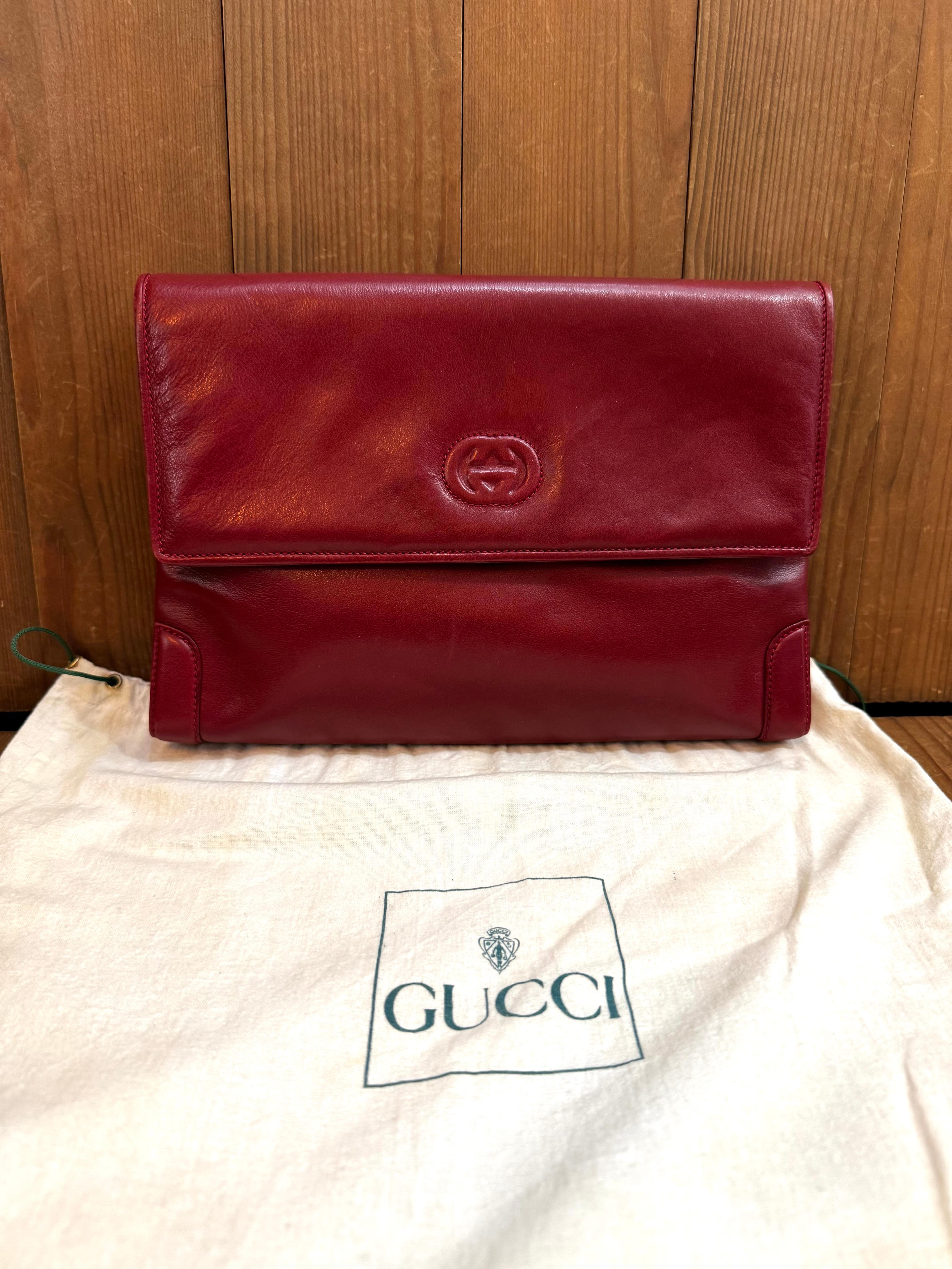 This vintage GUCCI clutch bag is crafted of calfskin leather in burgundy. Front flap magnetic snap closure opens to a nubuck leather interior in burgundy featuring a zippered pocket. Made in Italy. Measures approximately 10.5 x 7.5 x 1.5 inches.
