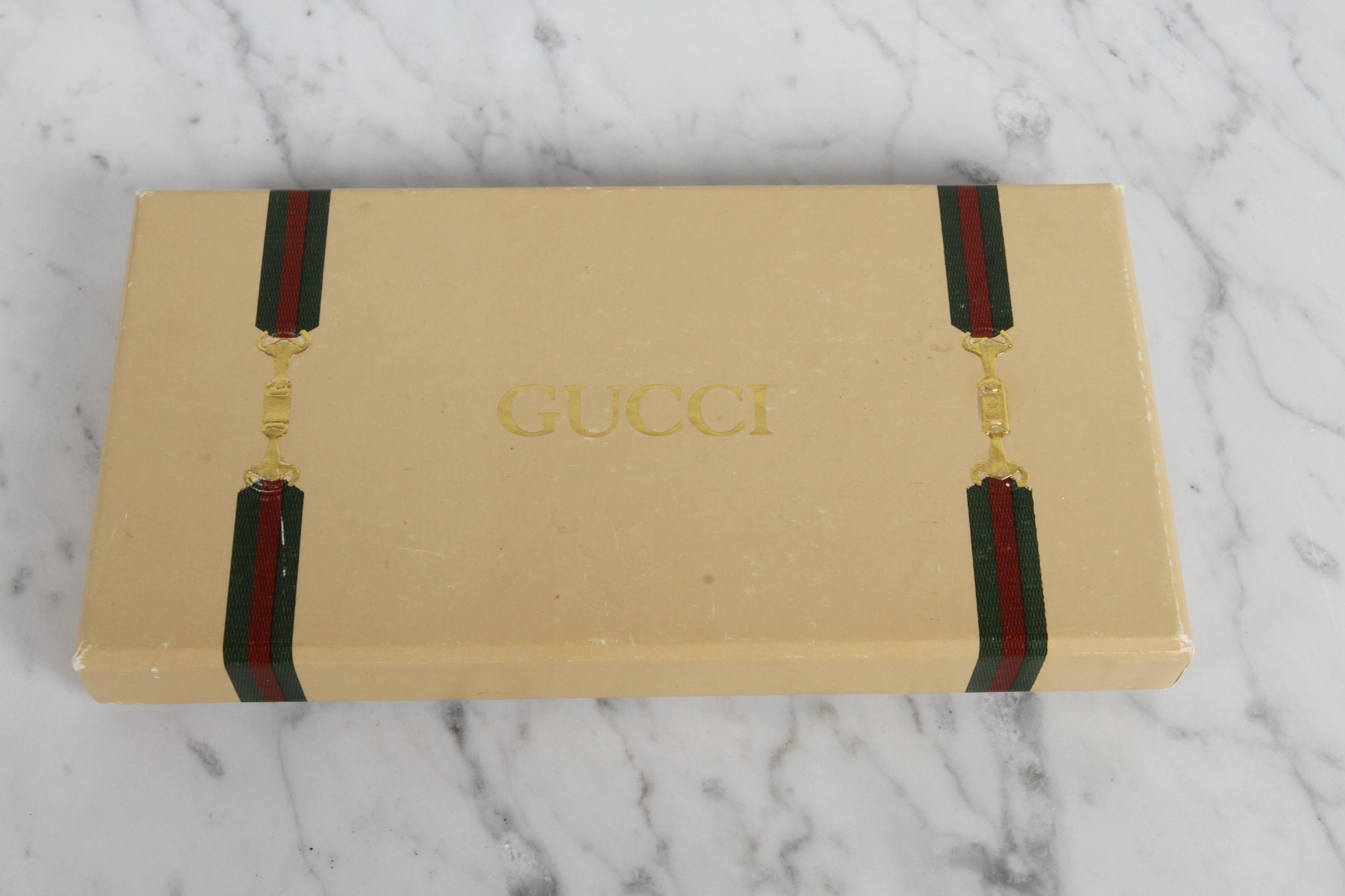 From the exuberant 1980s, this new old stock, in the original box vintage Gucci gold plated perfume bottle necklace / pendant is ready to be worn for the first time. Perfume tube has double GG at top, classic red & green stripe and Gucci made in