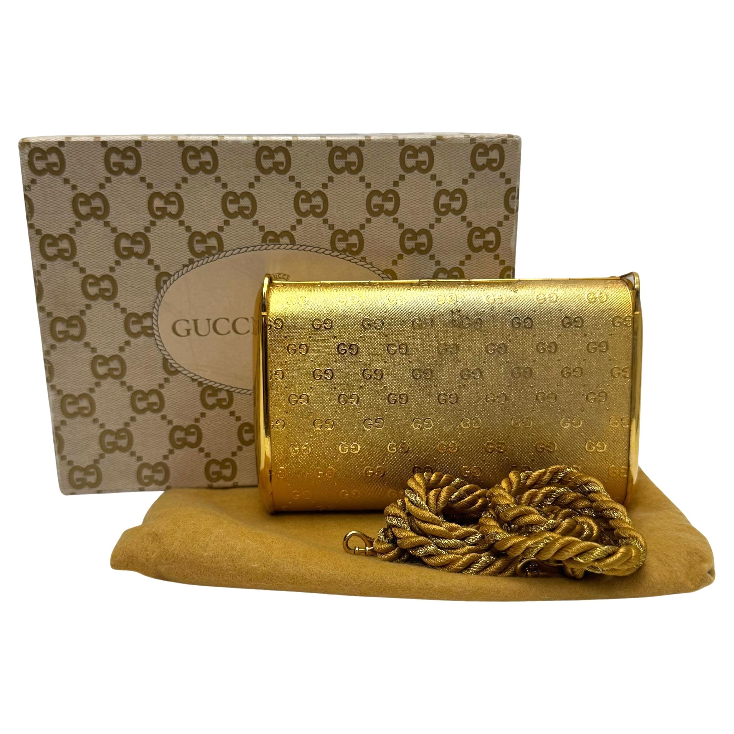 This vintage GUCCI clutch/crossbody bag is crafted of Gucci’s GG monogram in gold toned metal featuring a detachable gold-toned rope strap. Front flap closure opens to a black velvet interior featuring a mirror on the flap. Made in Italy. Measures