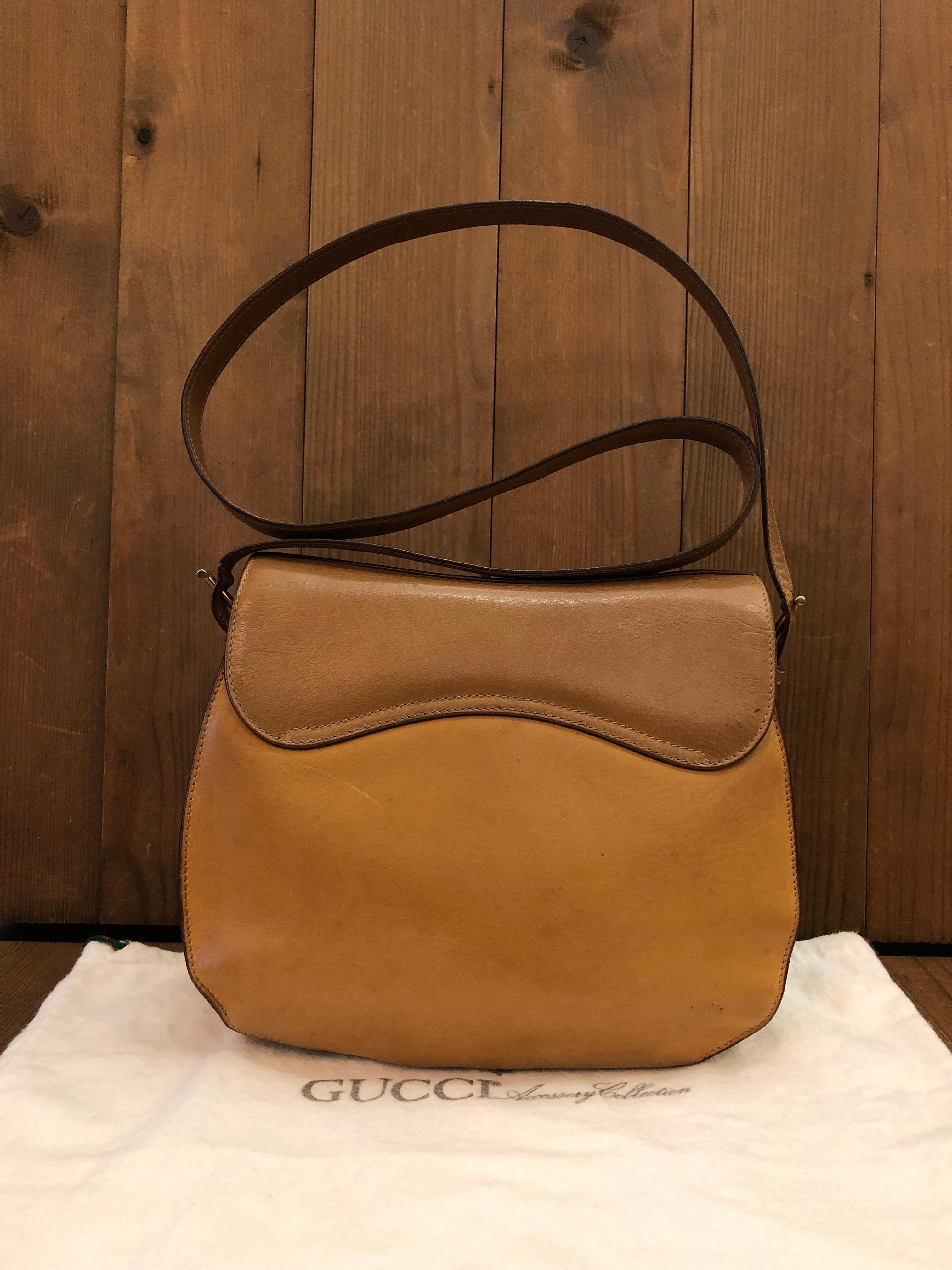 This 1980s vintage GUCCI saddle bag is crafted of smooth calfskin leather in camel featuring gold toned hardware and equestrian accent. Front magnetic snap closure opens to a neutral leather interior featuring a zippered pocket. Made in Italy.