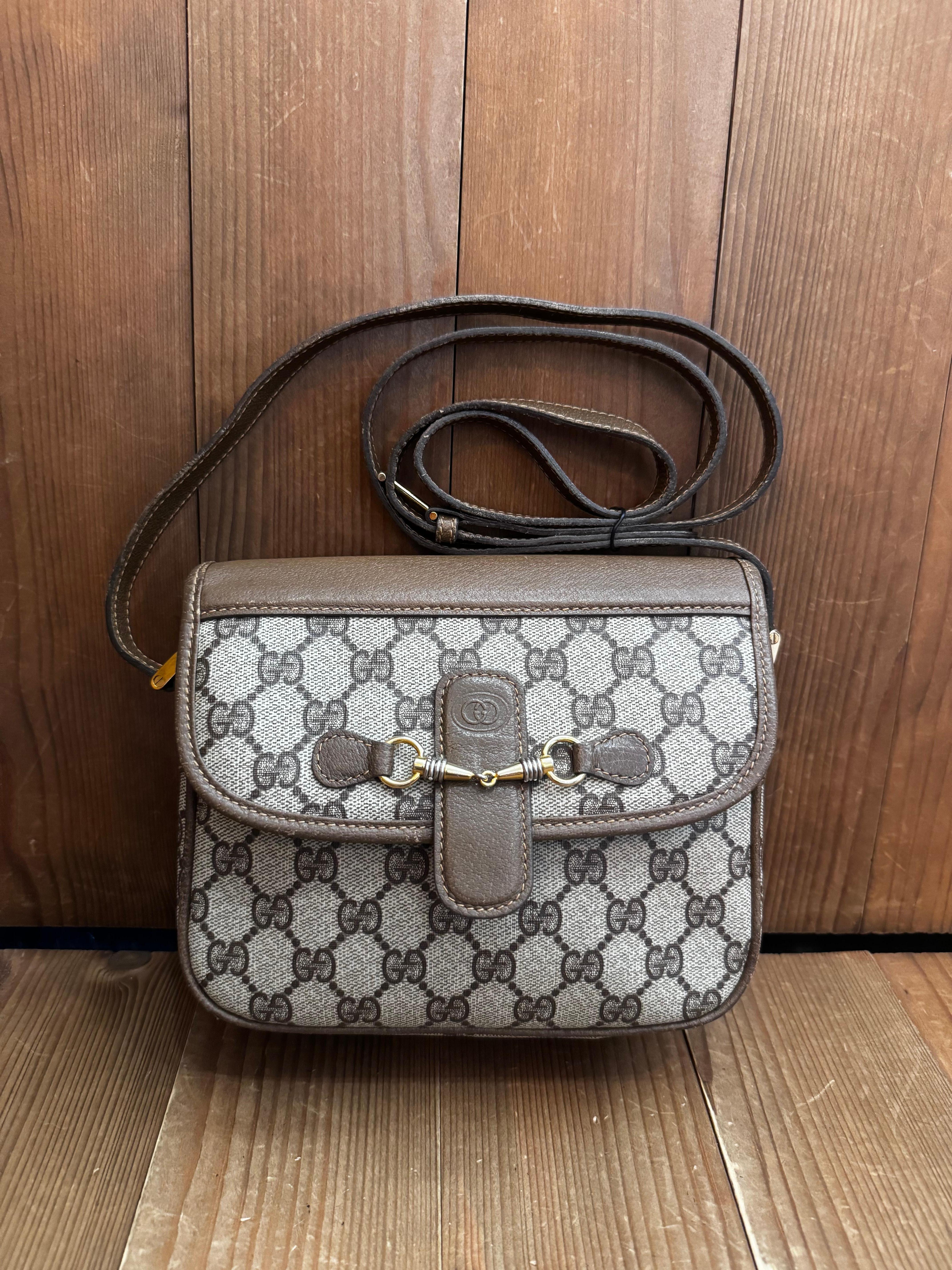 This vintage GUCCI crossbody bag is crafted of GG monogram coated canvas and pigskin leather in brown featuring gold toned hardware. Front flap magnetic snap closure opens to a coated interior in beige featuring a zippered pocket. Made in Italy.
