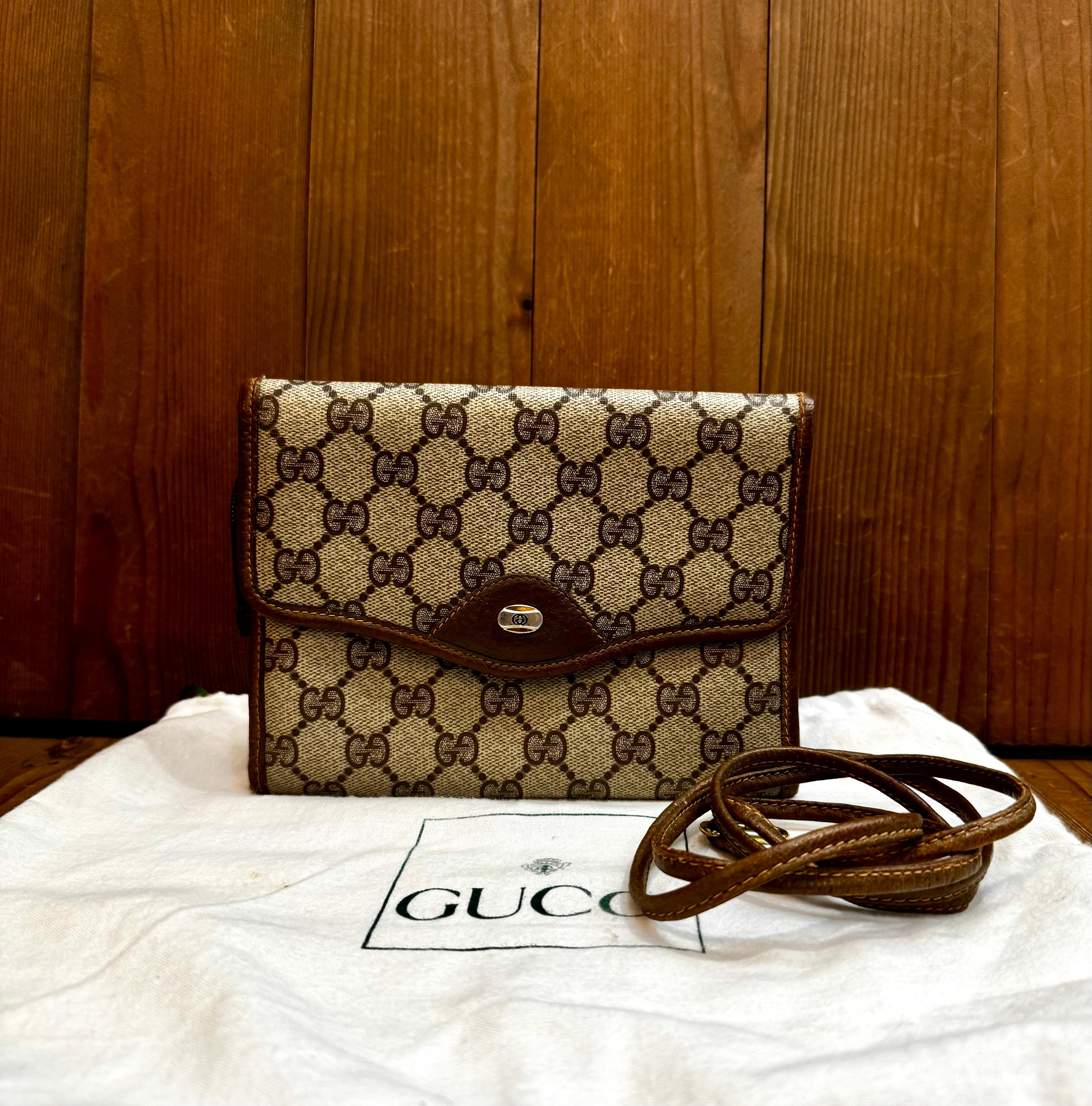 This vinatge GUCCI mini tri-fold crossbody bag is crafted of GG monogram canvas and pigskin leather in brown. Front snap closure opens to a coated interior which has been professionally cleaned featuring zippered pockets. The back of this Gucci also