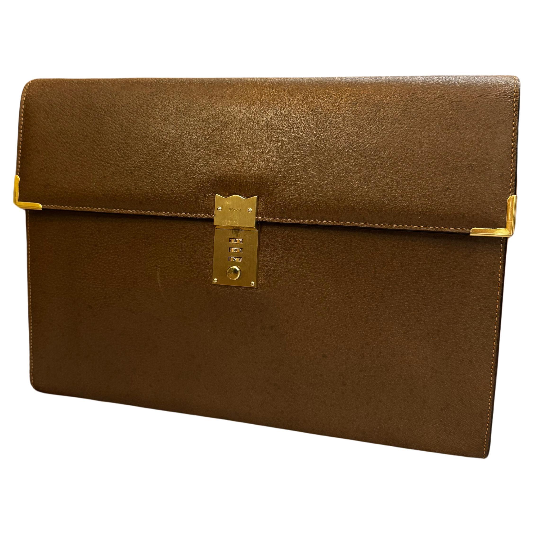 This vintage GUCCI business clutch bag is crafted of pigskin leather in brown featuring gold toned hardware. Front flap combination lock closure opens to a beige pigskin leather interior featuring a main compartment with zippered and front slip