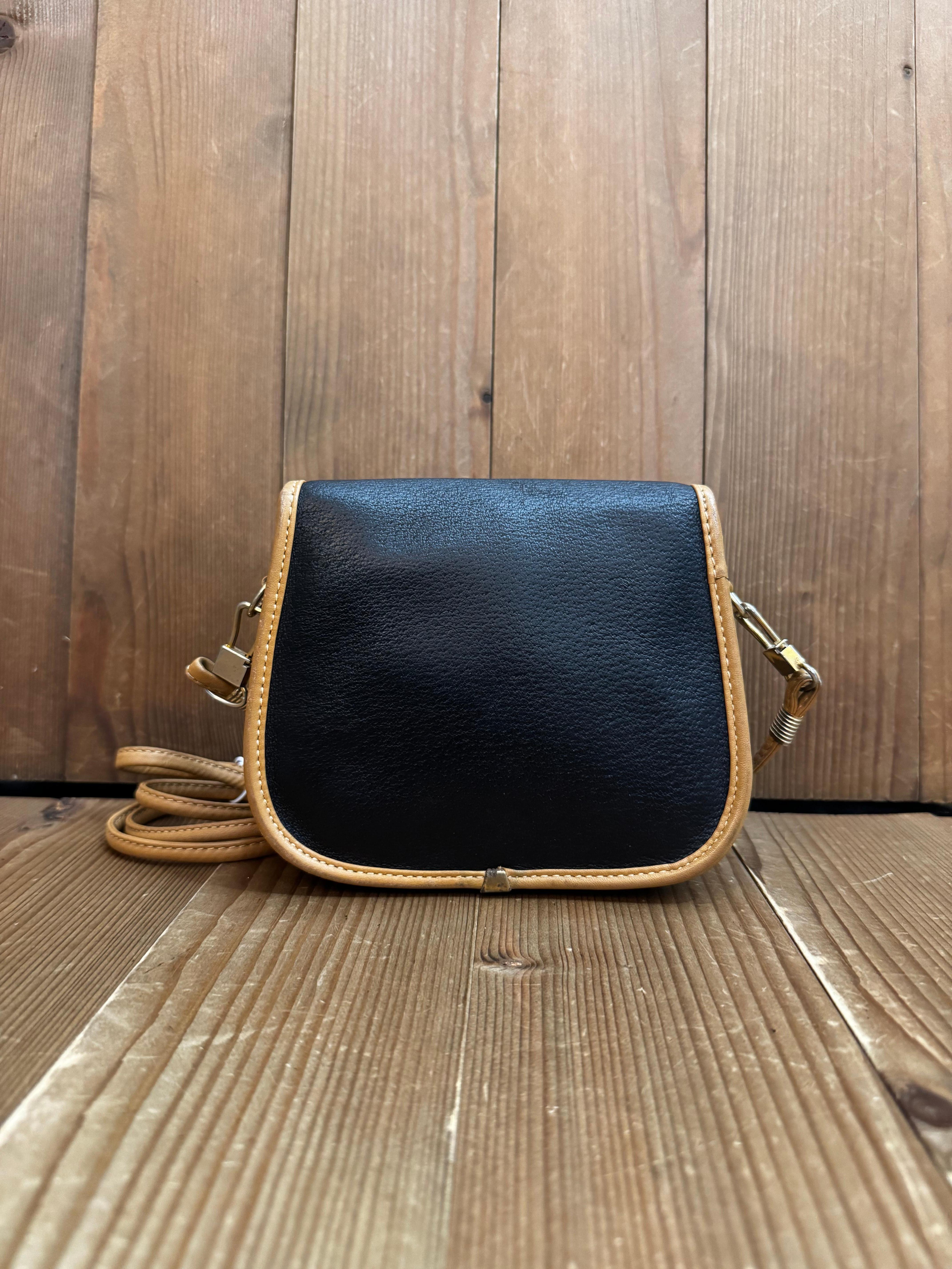 This vinatge GUCCI Plus mini crossbody bag is crafted of pigskin leather in black trimmed with smooth beige calfskin leather. Front flap magnetic snap closure opens to a beige velvet interior featuring a patch pocket. This Gucci Plus crossbody bag