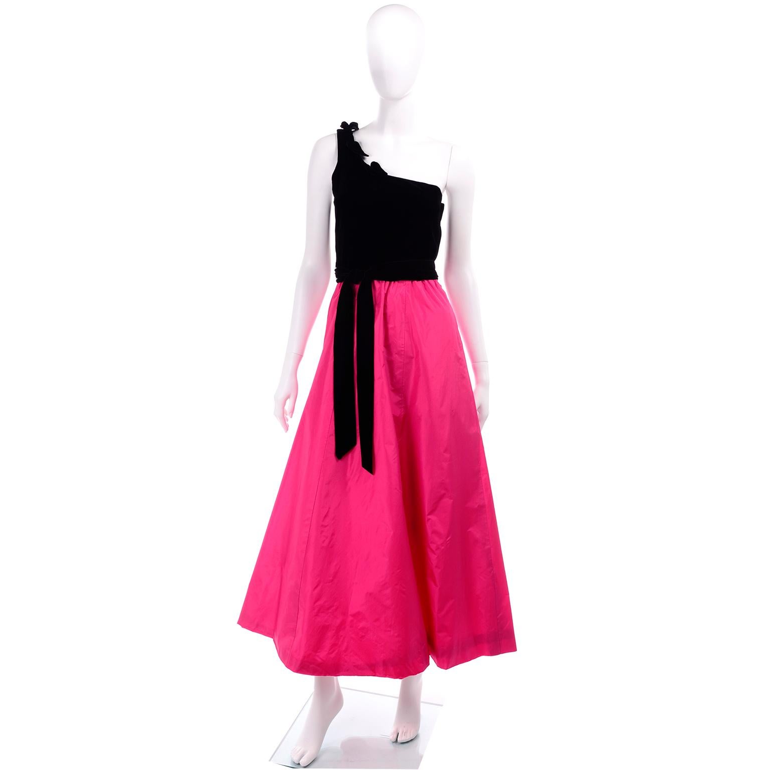 This vintage dress is from the 1980's and it would be perfect for a special evening event!  The dress has a one shoulder black velvet bodice with pretty cut out leaves, and a pretty hot pink taffeta skirt. The dress closes with a metal side zipper