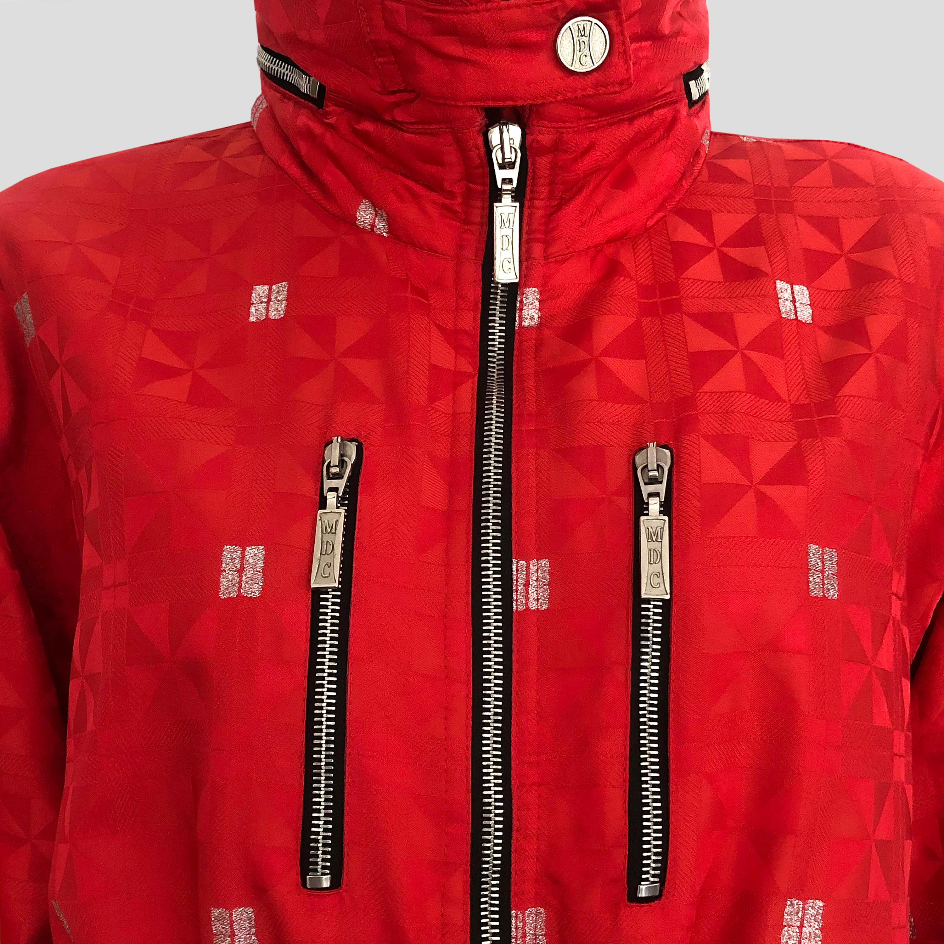 Product Details: 1980s Vintage Jacket - Red & Silver Geometric Sheen / Coated Cotton - ‘MDC’ Embossed Silver Hardware Throughout  - x 2 Front Pockets - Rolled-Up Inner Hood / Collar - Sleeve Zip Detail - Adjustable Drawstring Waist + Hem Ties -