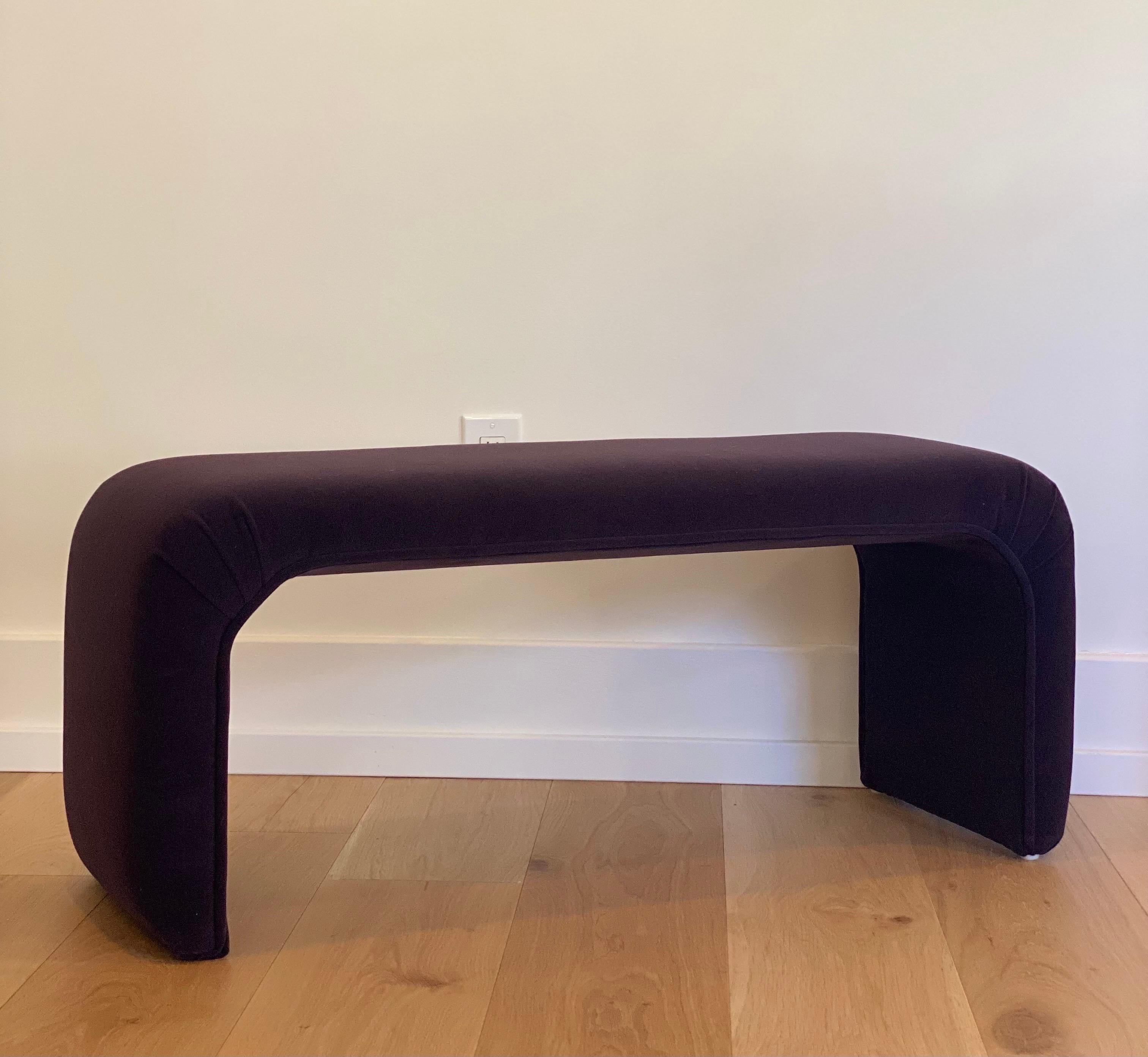 We are very pleased to offer a fabulous, Mid-Century Modern, upholstered bench in the manner of Karl Springer, circa the 1980s. Layer a space or add extra seating with this eye-catching bench wrapped in a new dark purple raisin mohair fabric. In
