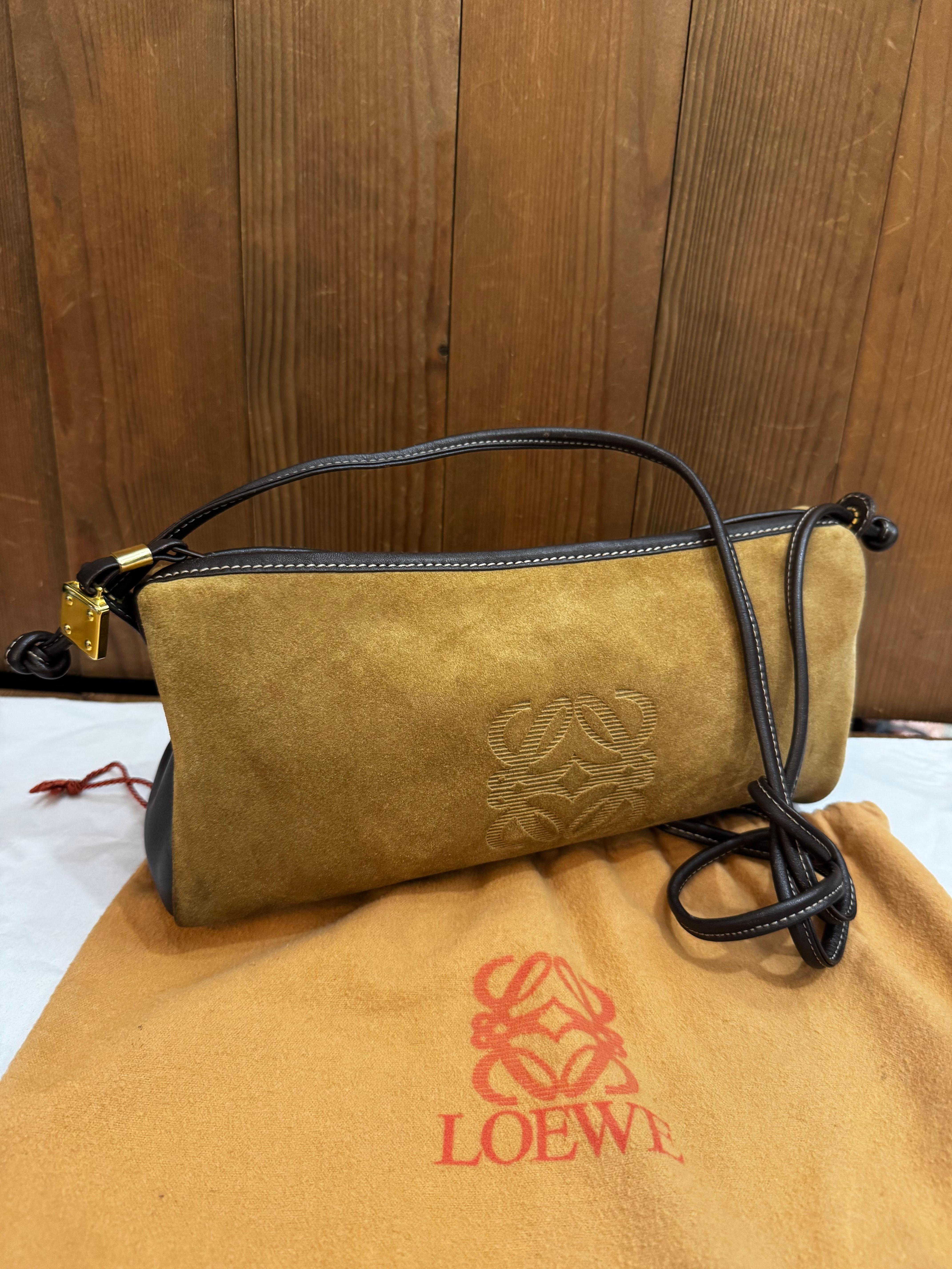 This vintage LOEWE Anagram triangular crossbody bag is crafted of calfskin suede and smooth leather in brown featuring gold toned hardware and a shoulder strap of the same leather. Top zipper closure opens to an interior of smooth calfskin leather