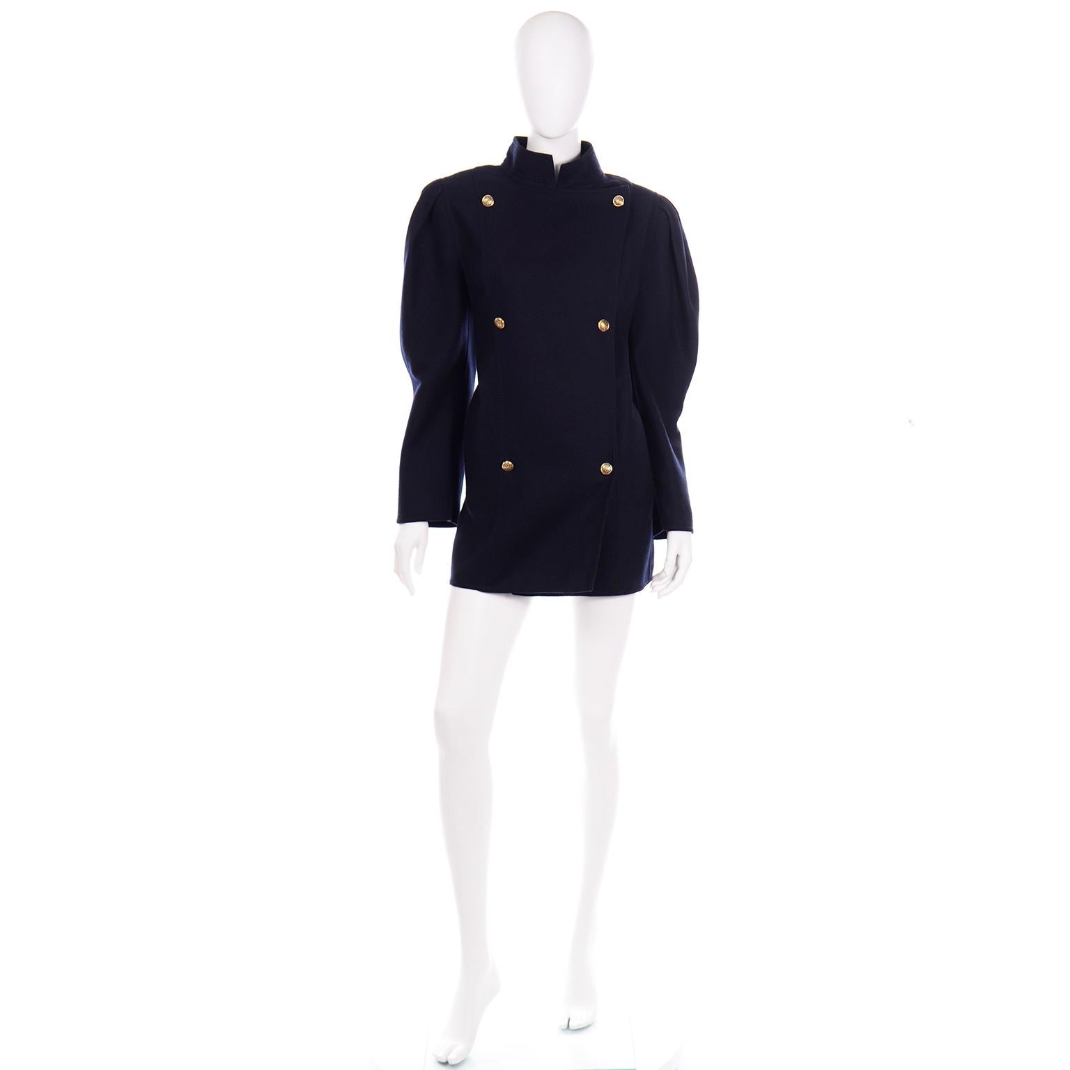 This is a fabulous midnight navy blue Louis Féraud military style coat with dramatic sleeves and unique chain link gold tone buttons. The shoulders of this great jacket are structured with shoulder pads and the box pleats at the seams give a