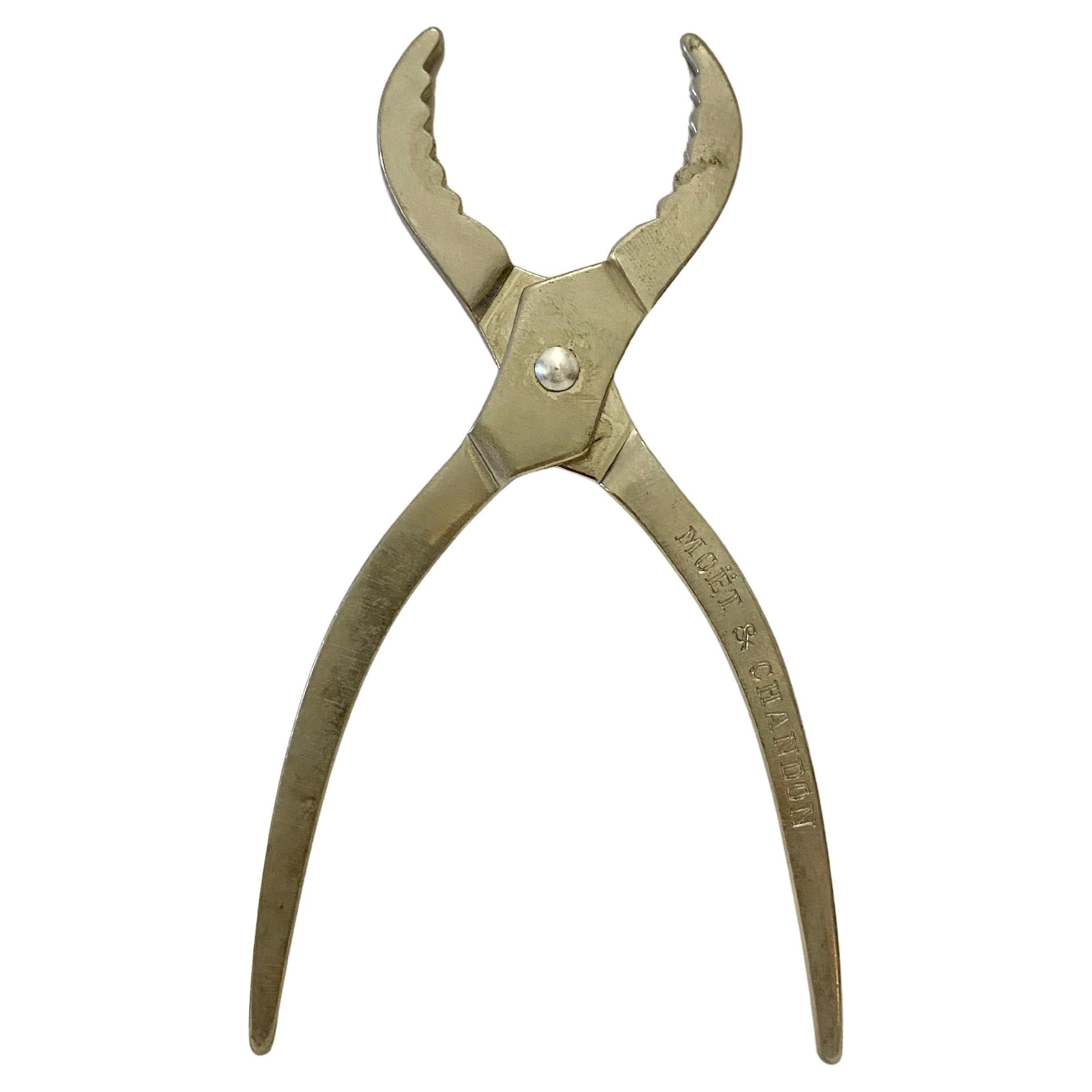 Moet And Chandon Champagne Cork Silver Metal Pliers, kompaktes Werkzeug zum Greifen von Champagnerkorken und -flaschen, gestempelt Moët & Chandon auf dem Griff, gekennzeichnet Made in France in einer vertieften ovalen Kartusche, Konstruktion aus