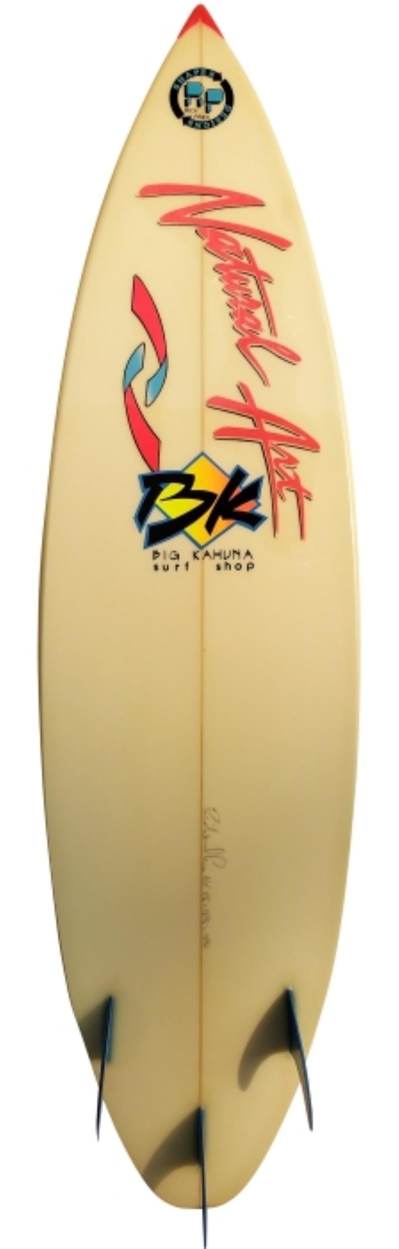 1988 Natural Art thruster (tri-fin) surfboard shaped by Rich Price. Featuring a neon orange/blue airbrush, matching original stomp pad, and blue glassed on fins. A great example of a 1980s vintage surfboard with retro airbrush design.