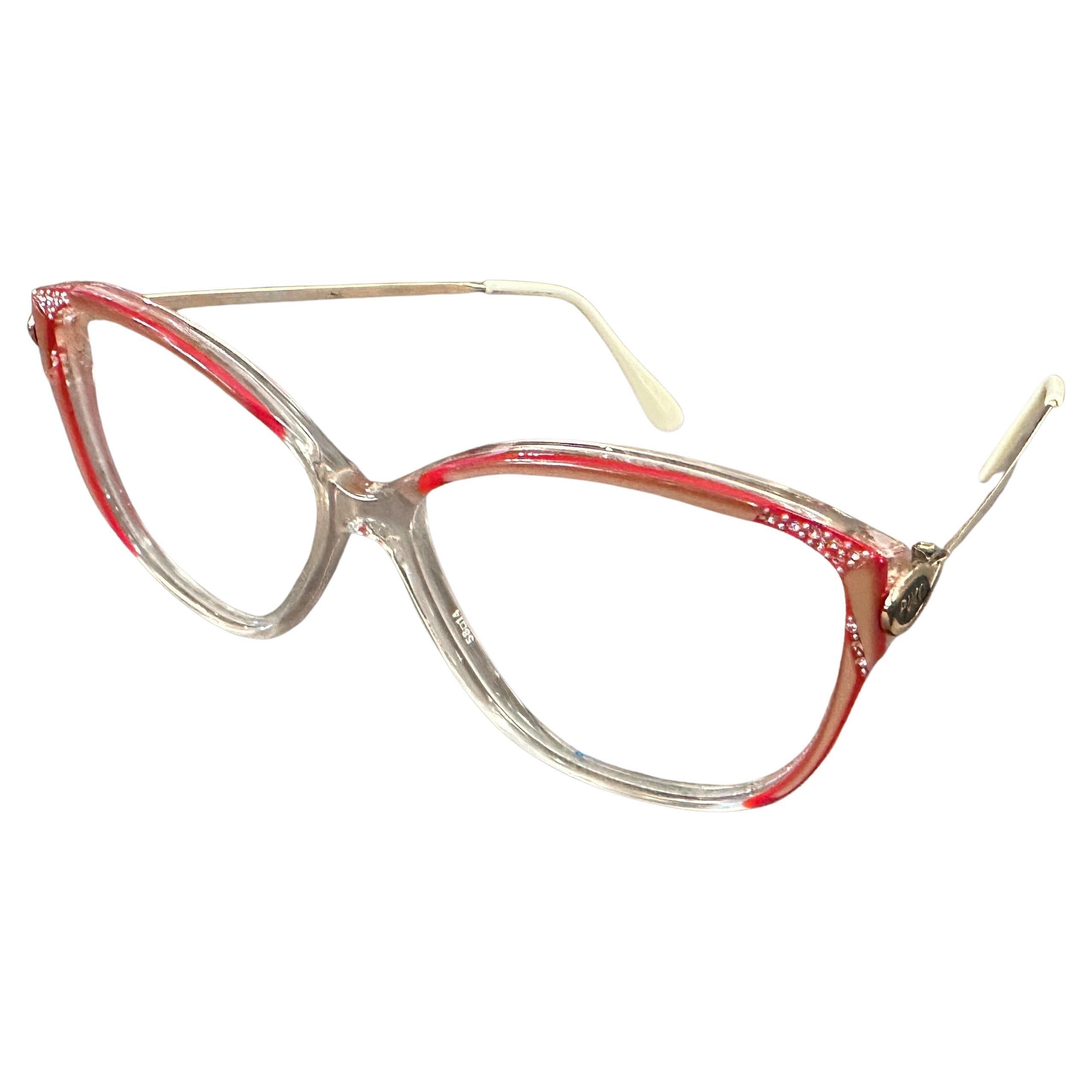 Estas exquisitas gafas vintage de Emilio Pucci son un accesorio por excelencia de los años 80, y encarnan el gusto de la marca por el diseño atrevido y vibrante. Las monturas de ojo de gato de gran tamaño presentan un cautivador efecto bicolor con