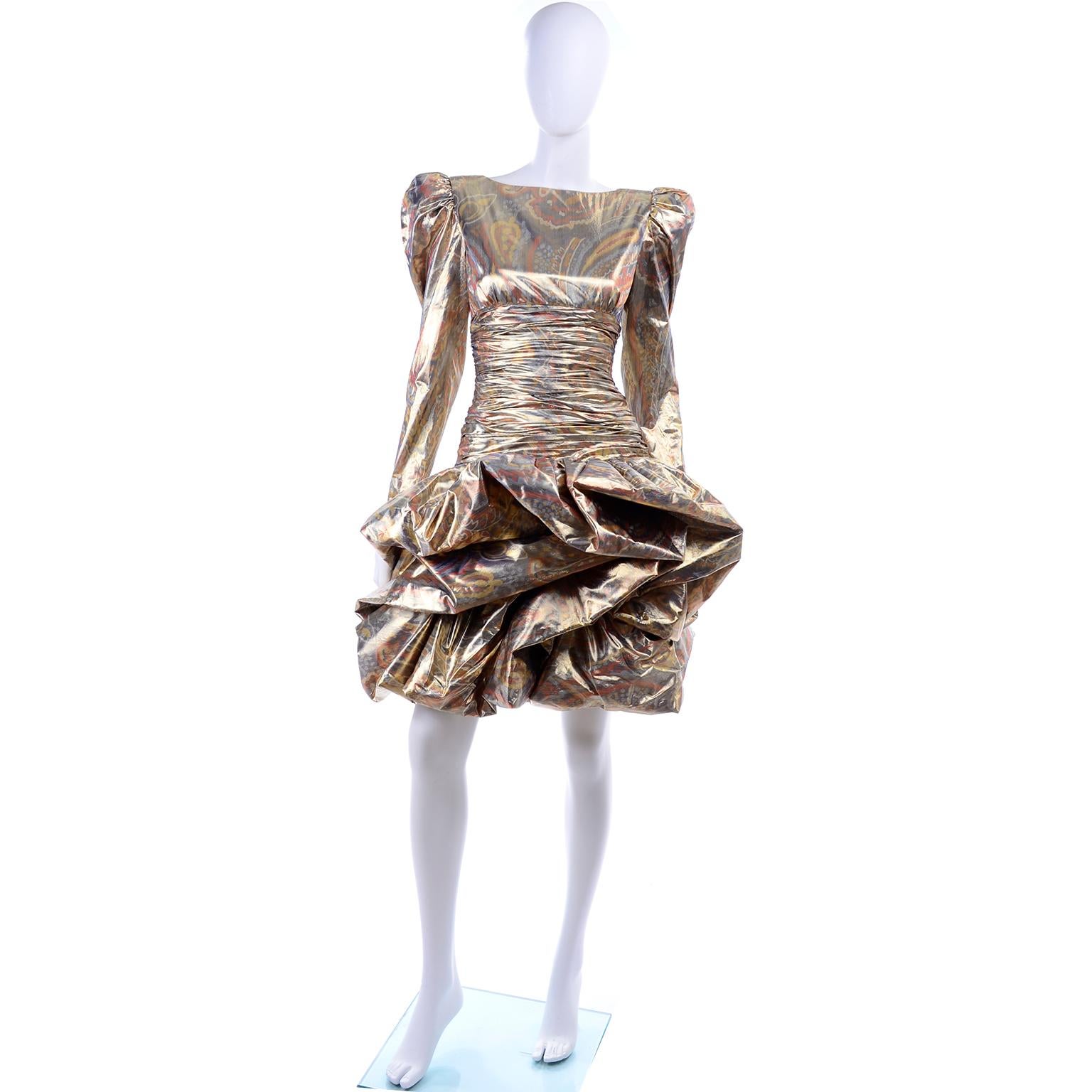 This sensational vintage dress from the 1980's is made in an exquisite lame fabric in shades of copper, gold, bronze and silver in an abstract paisley pattern.  This dramatic dress has gathered shoulders with shoulder pads, a wide ruched waist, and