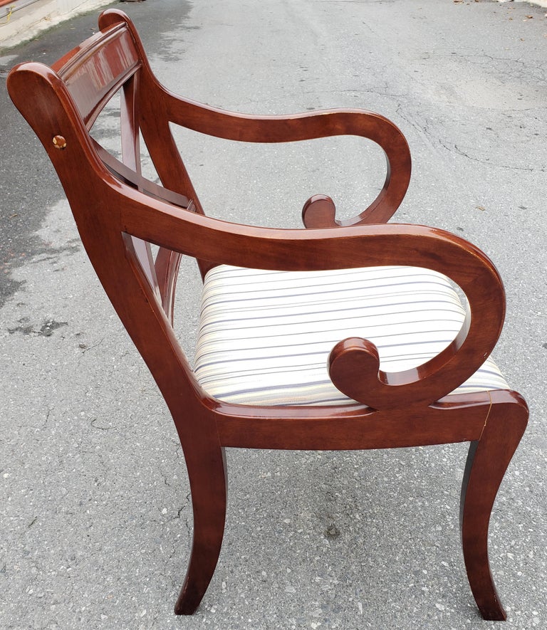 A pair of Regency style armchairs in mahogany. Lacquered finish. Upholstered seat. Finish in still in very good condition. Frame Joins were reinforced under the seats and two joins appear to have been repaired and barely noticeable to our opinion.