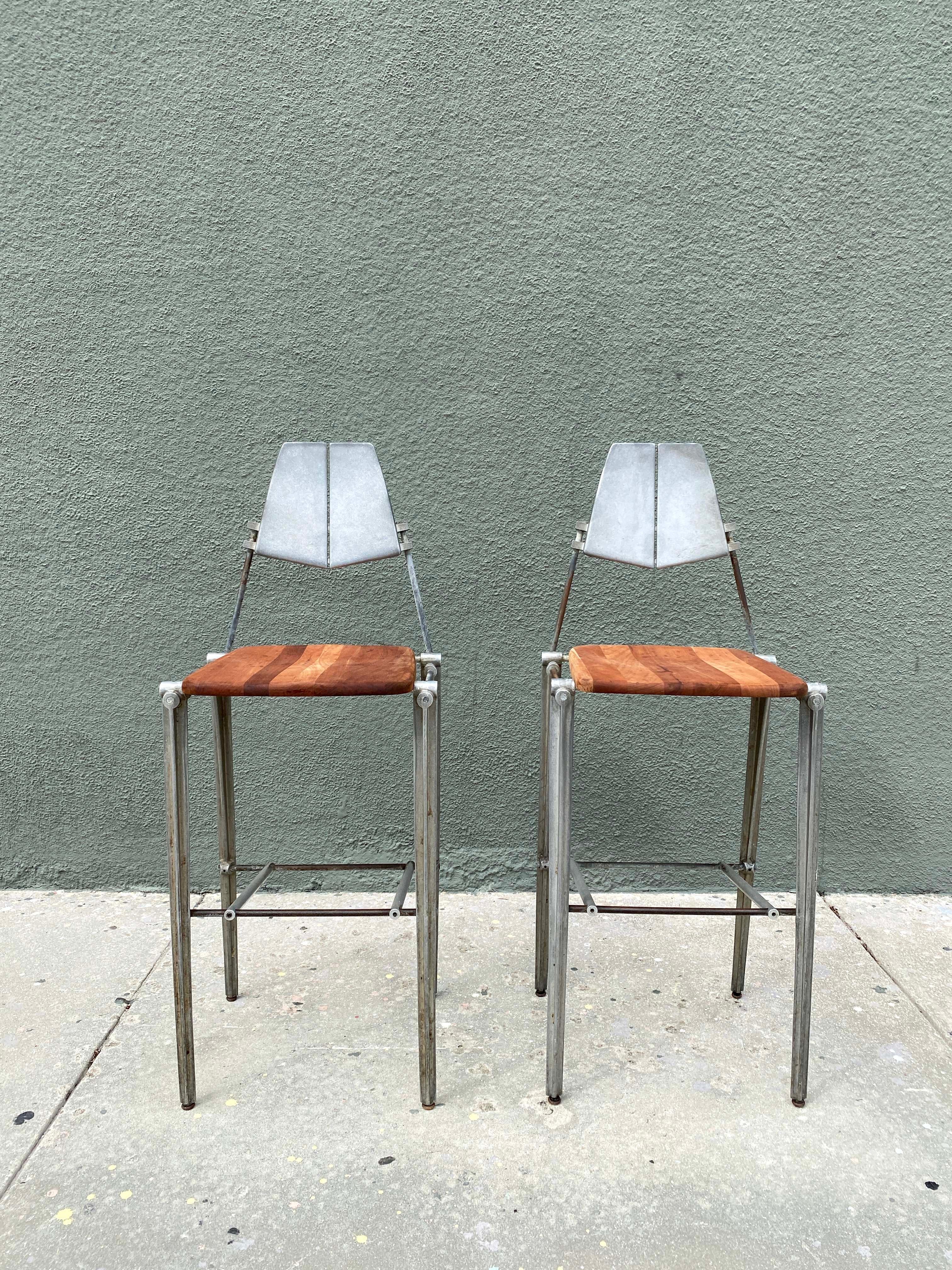 Designed by Robert Josten, these cast aluminum bar stools feature sculpted aluminum backs or frames along with a comfortably molded Teak wooden seat. Circa 1980s.

Measures: 47.5”H x 18.5”W x 18”D x 30.5”Seat H.