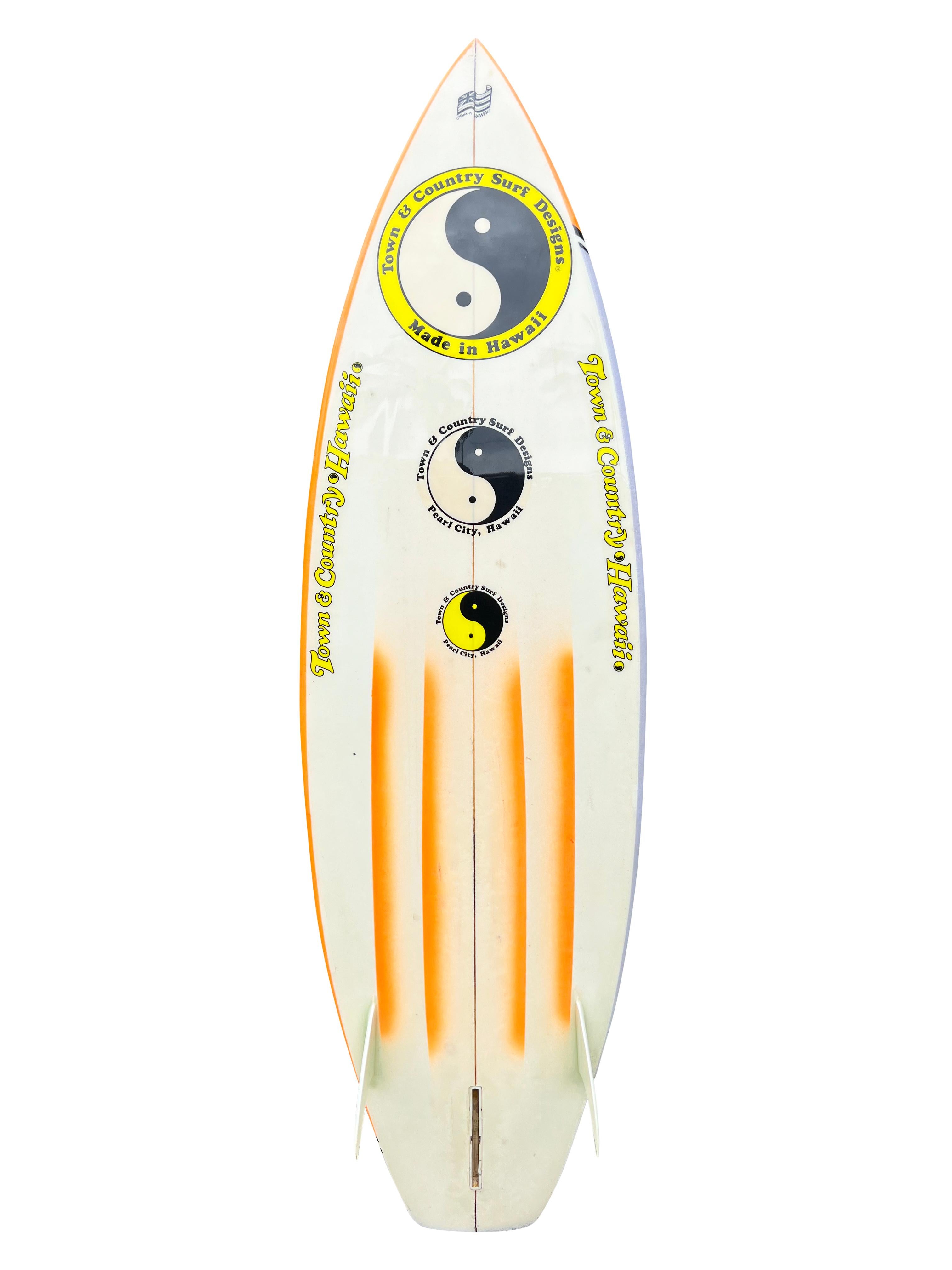 Planche de surf Townes & Country de 1983 fabriquée par Nev Hyman. Il est doté d'un remarquable design aérographe au style des années 1980. Queue de courge à fond de canal. Nev Hyman, fondateur et copropriétaire de FireWire Surfboards. FireWire est