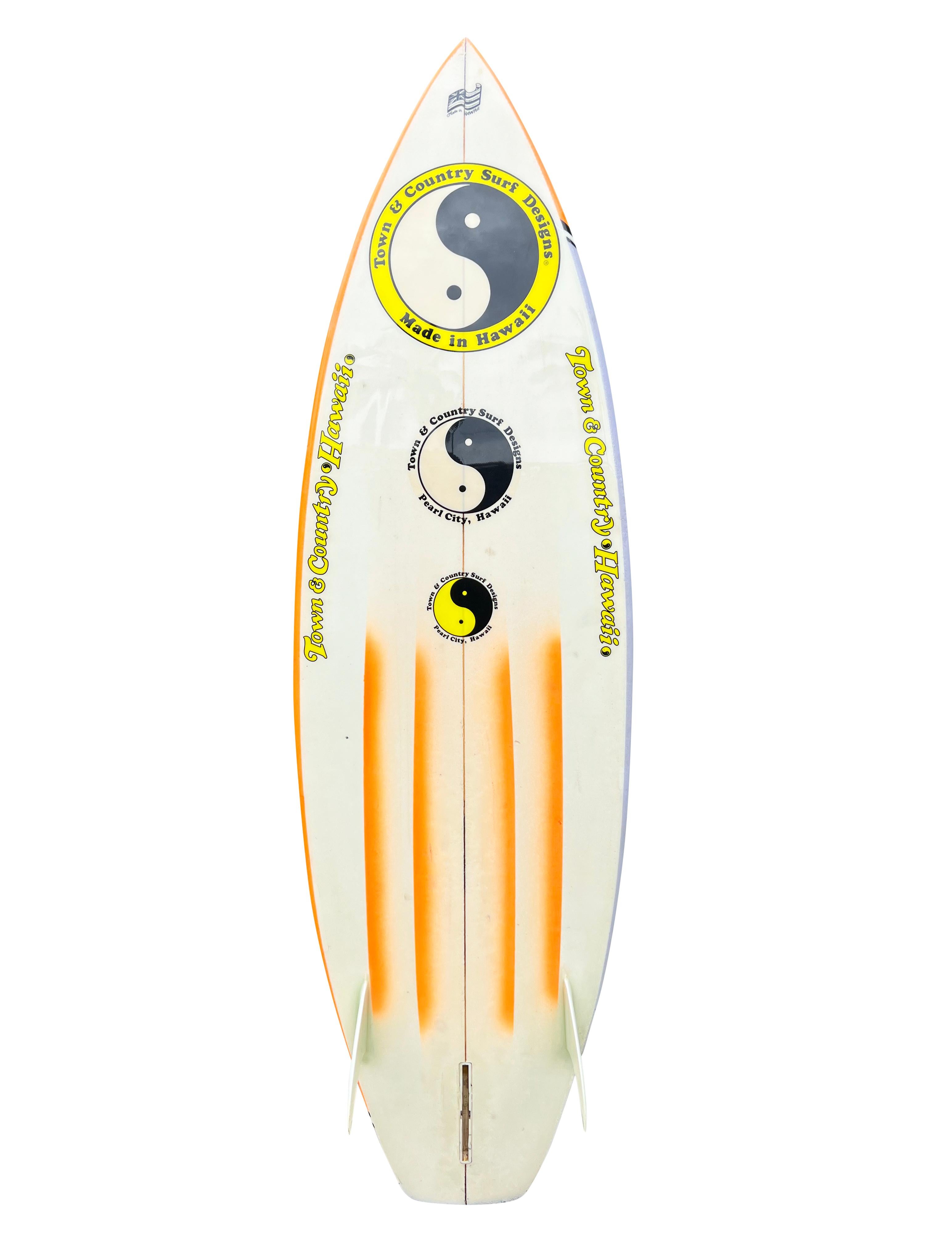 Tavola da surf Town & Country del 1983 realizzata da Nev Hyman. Presenta un notevole design ad aerografo con uno stile anni '80. Coda di squash a fondo canale. Nev Hyman, fondatore e co-proprietario di FireWire Surfboards. FireWire è una delle