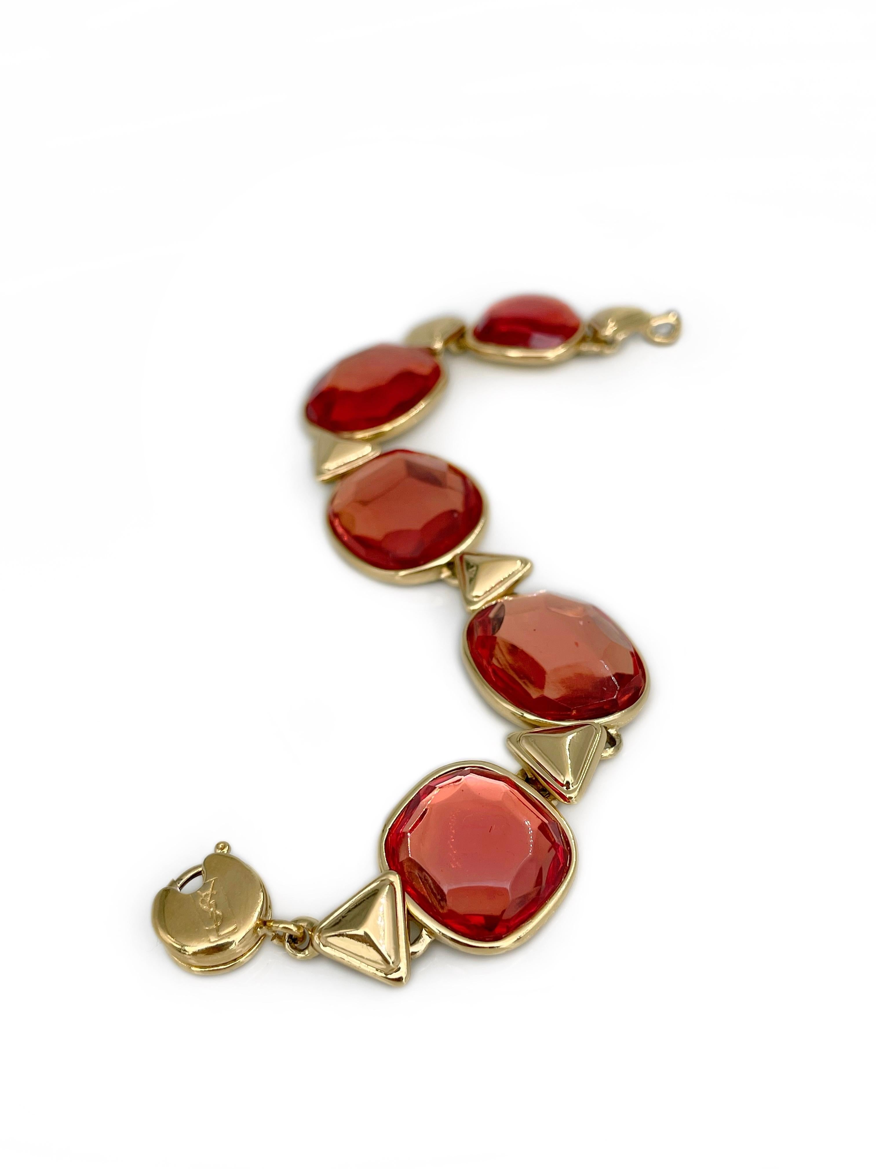 Si tratta di un bracciale a maglie in tonalità oro disegnato da YSL nel 1980. Il pezzo è placcato in oro e presenta una resina sfaccettata rosso-arancio. 

C'è una collana adatta della stessa collezione nella nostra inserzione. 

Firmato: 