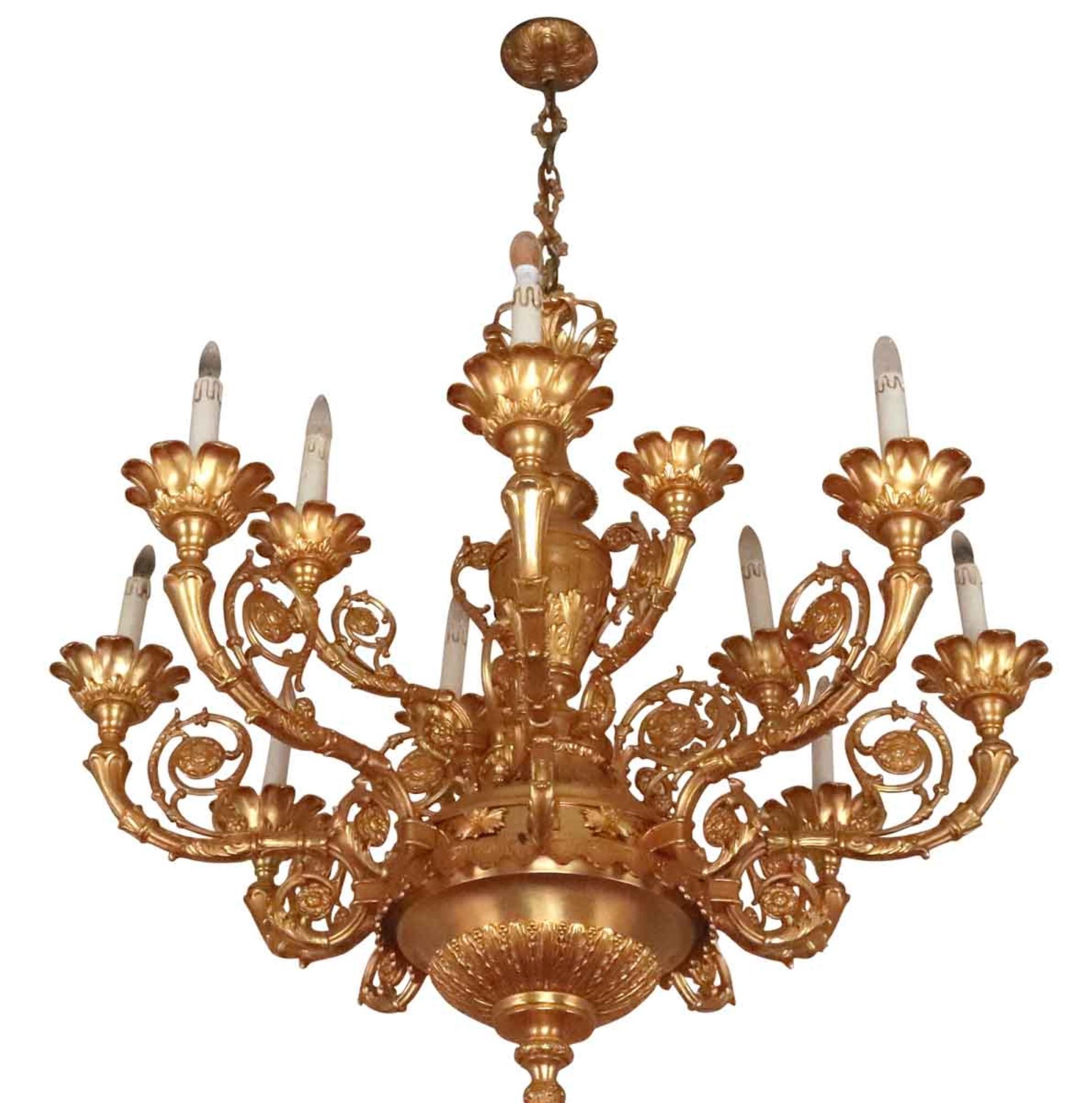12-arm French chandelier with highly ornate detail with gold gilt over bronze in the Louis XVI style. Elegant scroll and leafy floral detail decorates the bronze arms. This is from The Holland Room of the Waldorf Astoria Hotel. Price includes